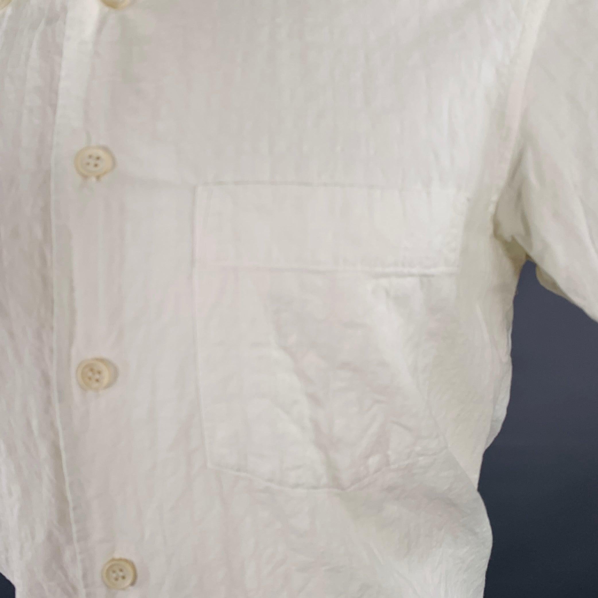 Camiseta de manga corta ISSEY MIYAKE
en un tejido de algodón blanco con un diseño arrugado, un bolsillo y cierre de botón. Fabricado en Japón.Excelente estado de conservación.  

Marcado:   JP 1 

Medidas: 
 
Hombro 15,5 pulgadas Pecho: 39 pulgadas
