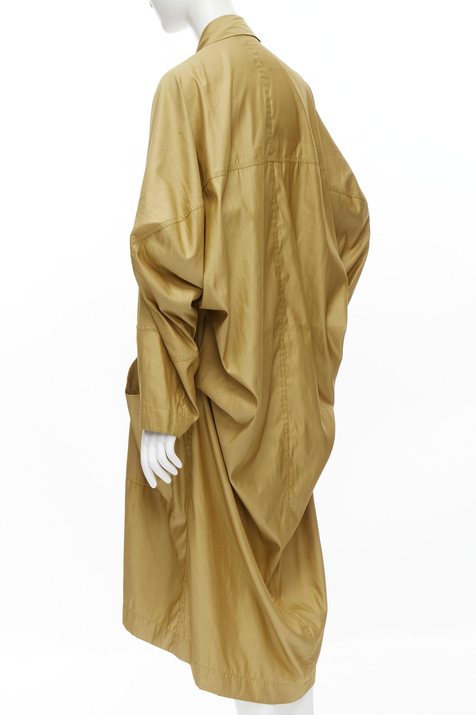ISSEY MIYAKE Vintage 1980s gold beige parachute draped back trench coat M 
Reference: CRTI/A00552 
Brand: Issey Miyake 
Collection: 1980's 
Color: Beige 
Pattern: Solid 
Closure: Button 
Extra Detail: Oversized fit. Draped parachute back. Double