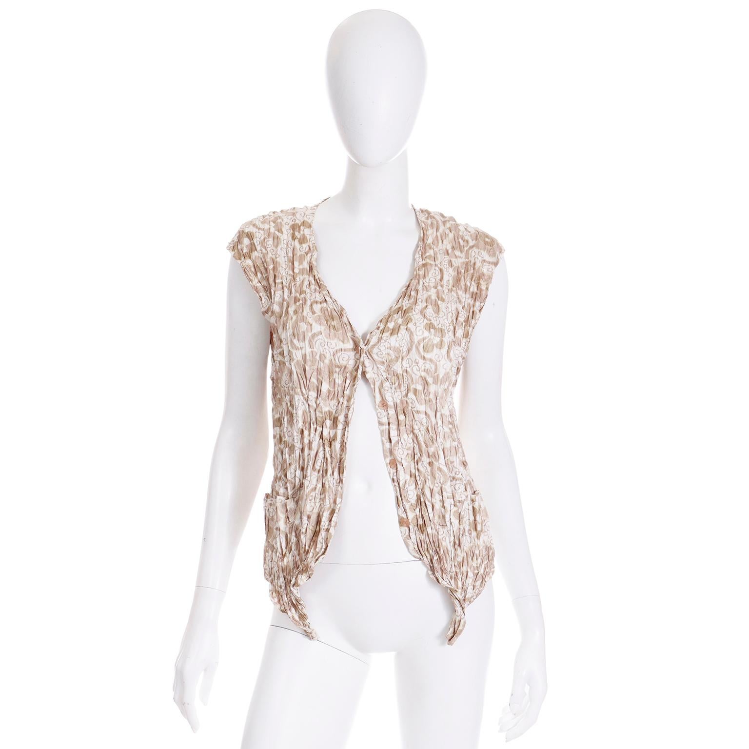 This is such a great piece from Issey Miyake! this open front vintage crinkle top can be worn over a variety of things and because of the flexible fit, it can accommodate a wide range of sizes. The top is in neutral shades of tan brown and white. we