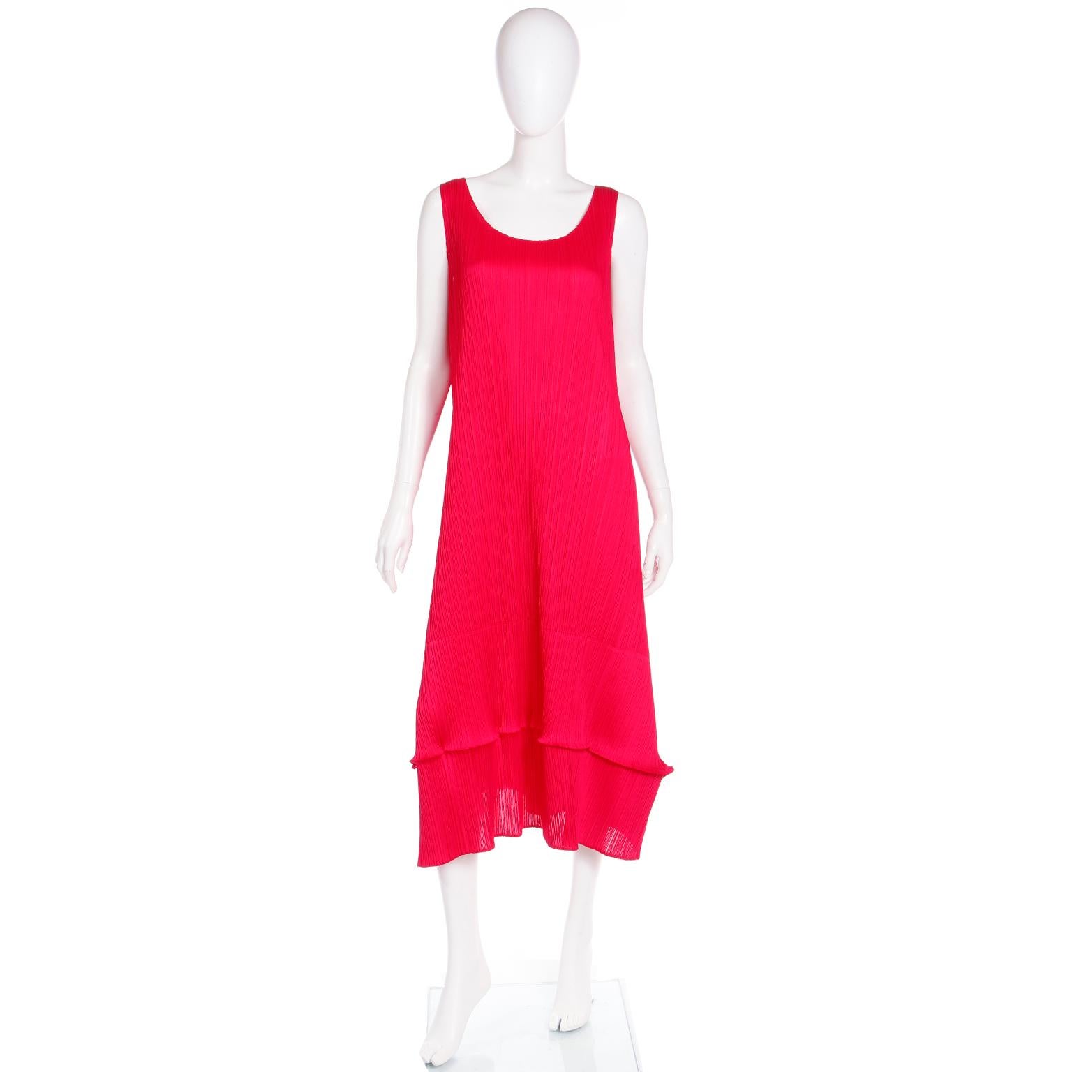 This bold raspberry red Issey Miyake Pleats Please Dress has hundreds of horizontal plisse pleats (8 per inch) that span the length of the dress. The top of the dress is a sleeveless tank and it extends just above the ankle length with an A-line