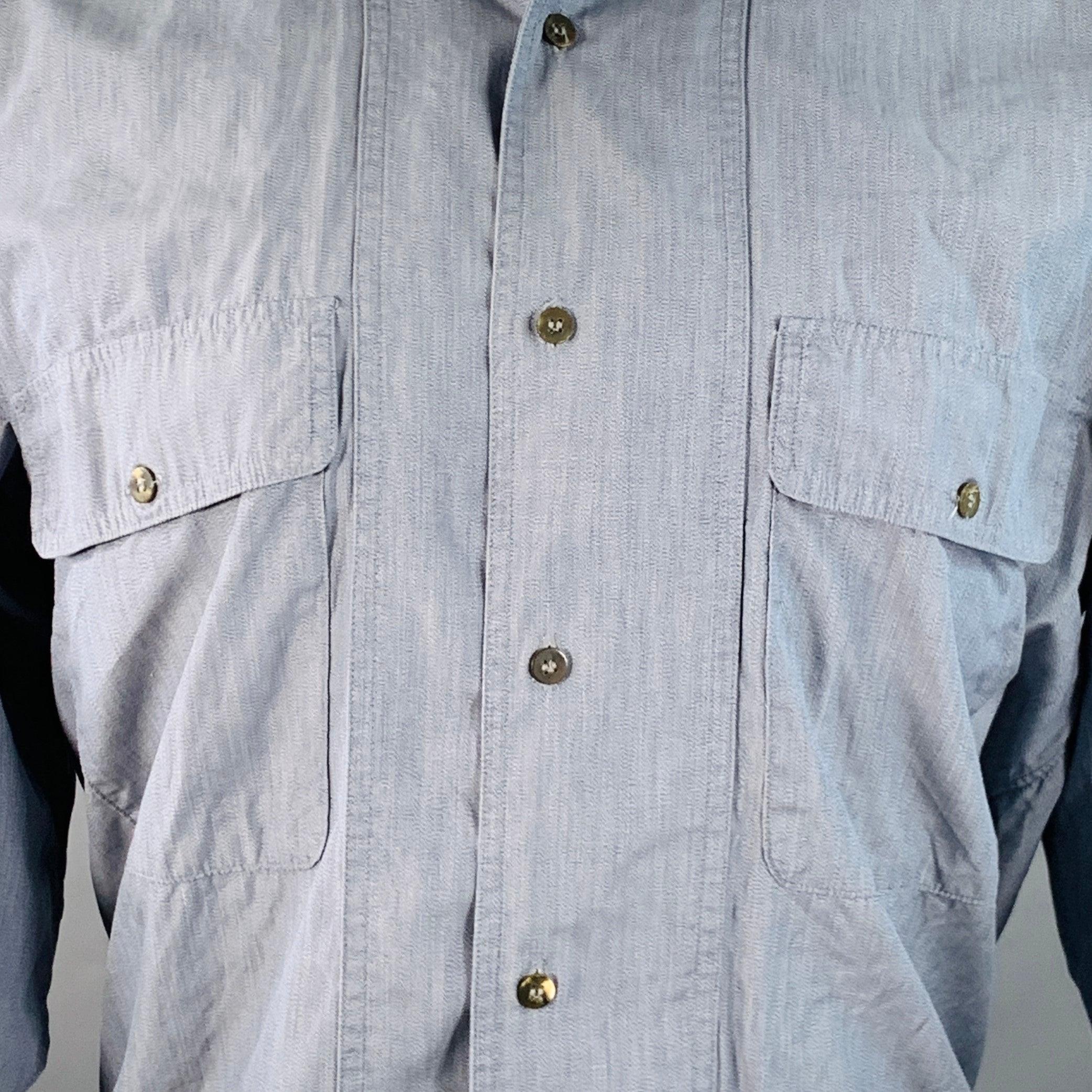 Camicia vintage a maniche lunghe Issey Miyake
in chambray di cotone blu con colletto Nehru, due tasche con patta e chiusura con bottoni. Made in Japan.Eccellente condizione di usato. L'etichetta per la cura del tessuto è sbiadita. 

Contrassegnato: 