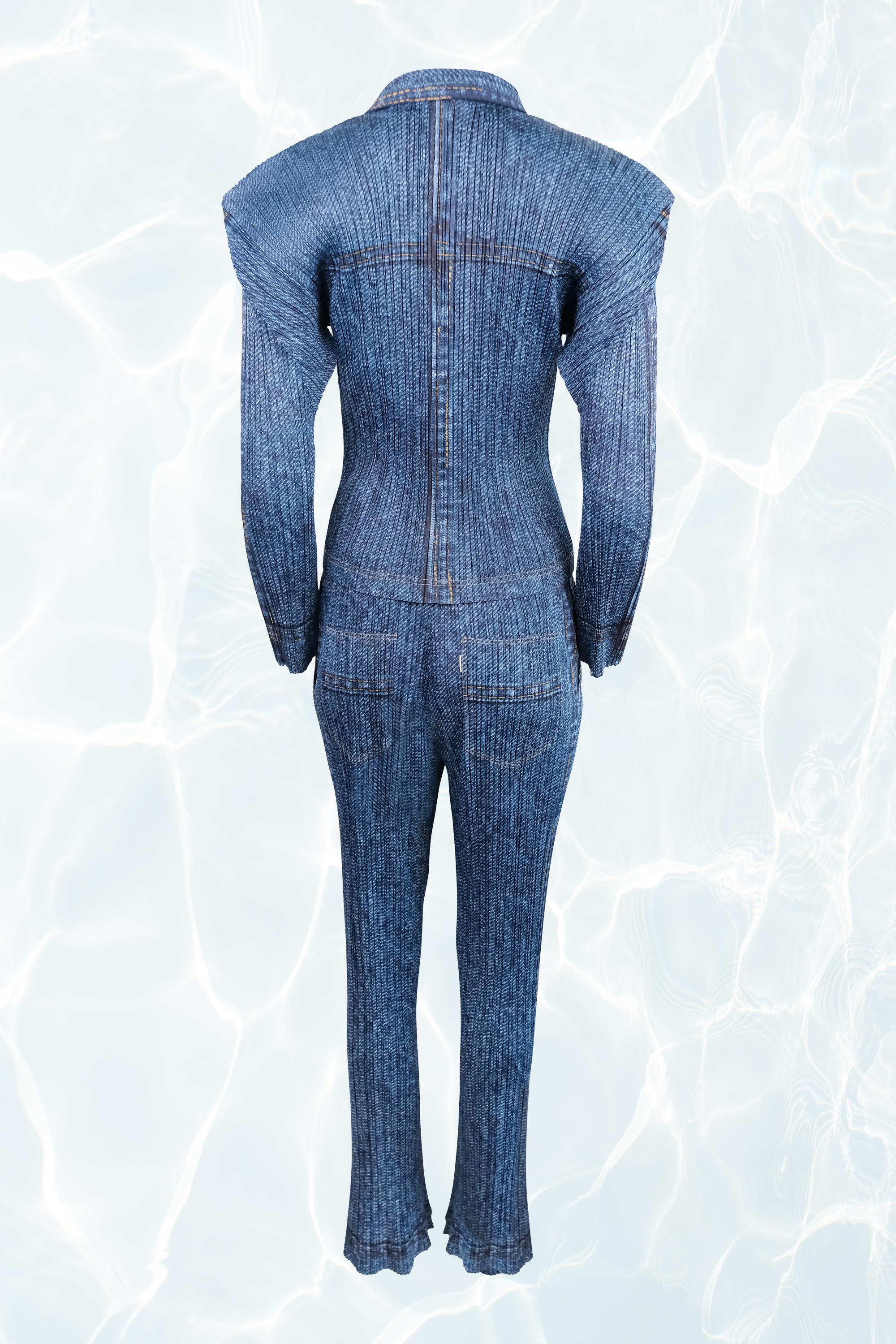 This Issey Miyake set blends sophistication with a laid-back aesthetic, offering a denim-inspired look with the brand’s signature pleated construction. The two-piece ensemble features a button-up top with long sleeves, a classic collar, and