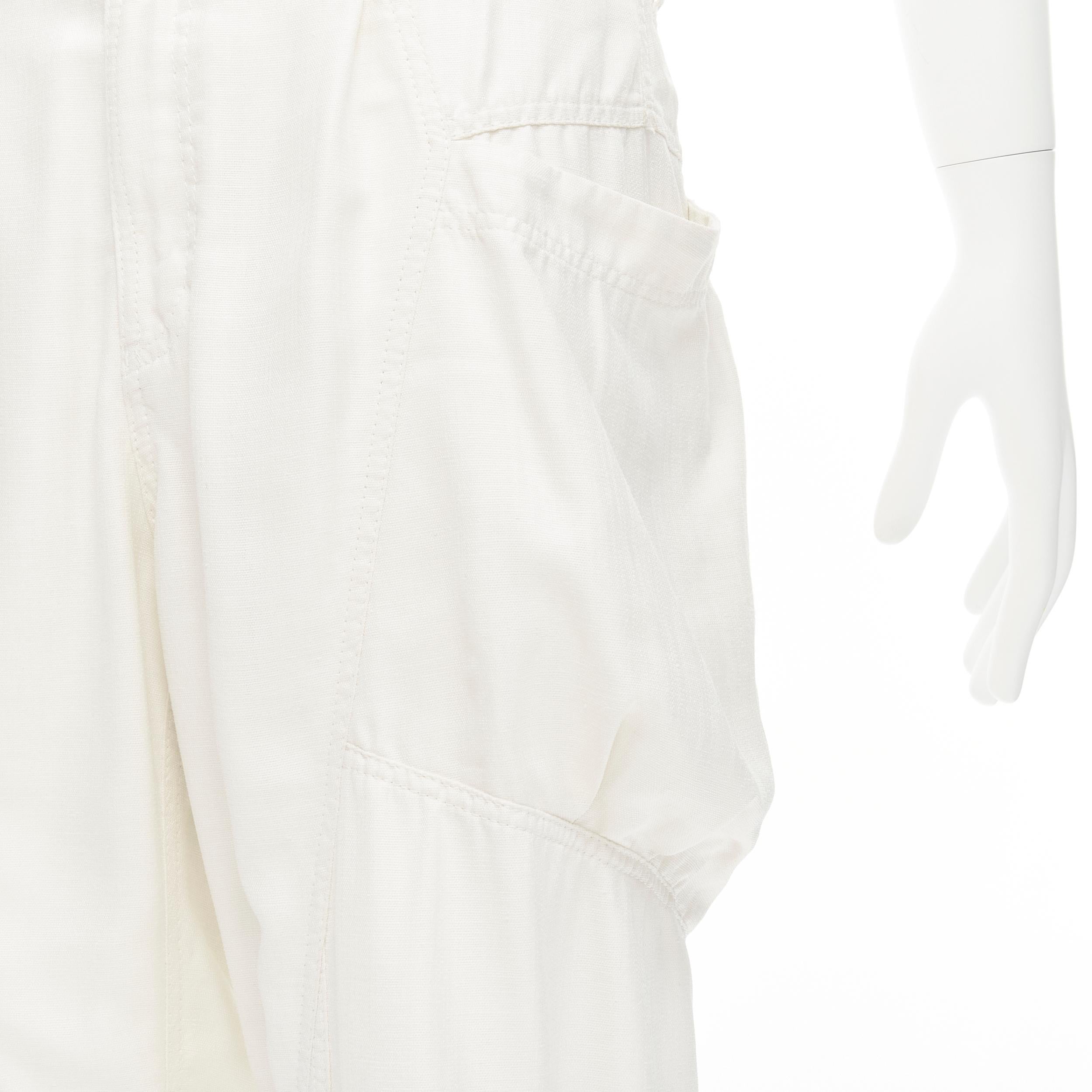 ISSEY MIYAKE white polyester cargo pocket dropped crotch parachute pants JP4 L 
Reference: AEMA/A00106 
Brand: Issey Miyake 
Material: Polyester 
Color: White 
Pattern: Solid 
Closure: Zip 
Extra Detail: Button cuffed hem. Concealed zip fly. 
Made