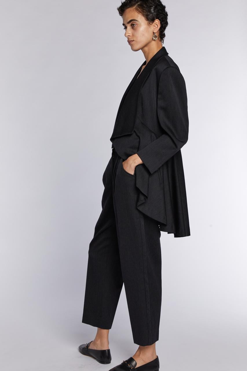 1980er Kollektion von Issey Miyake

Grauer Wollanzug mit hochtaillierter Hose mit Gürtel und Jacke mit fließendem Revers/Saum

Hergestellt in Japan 