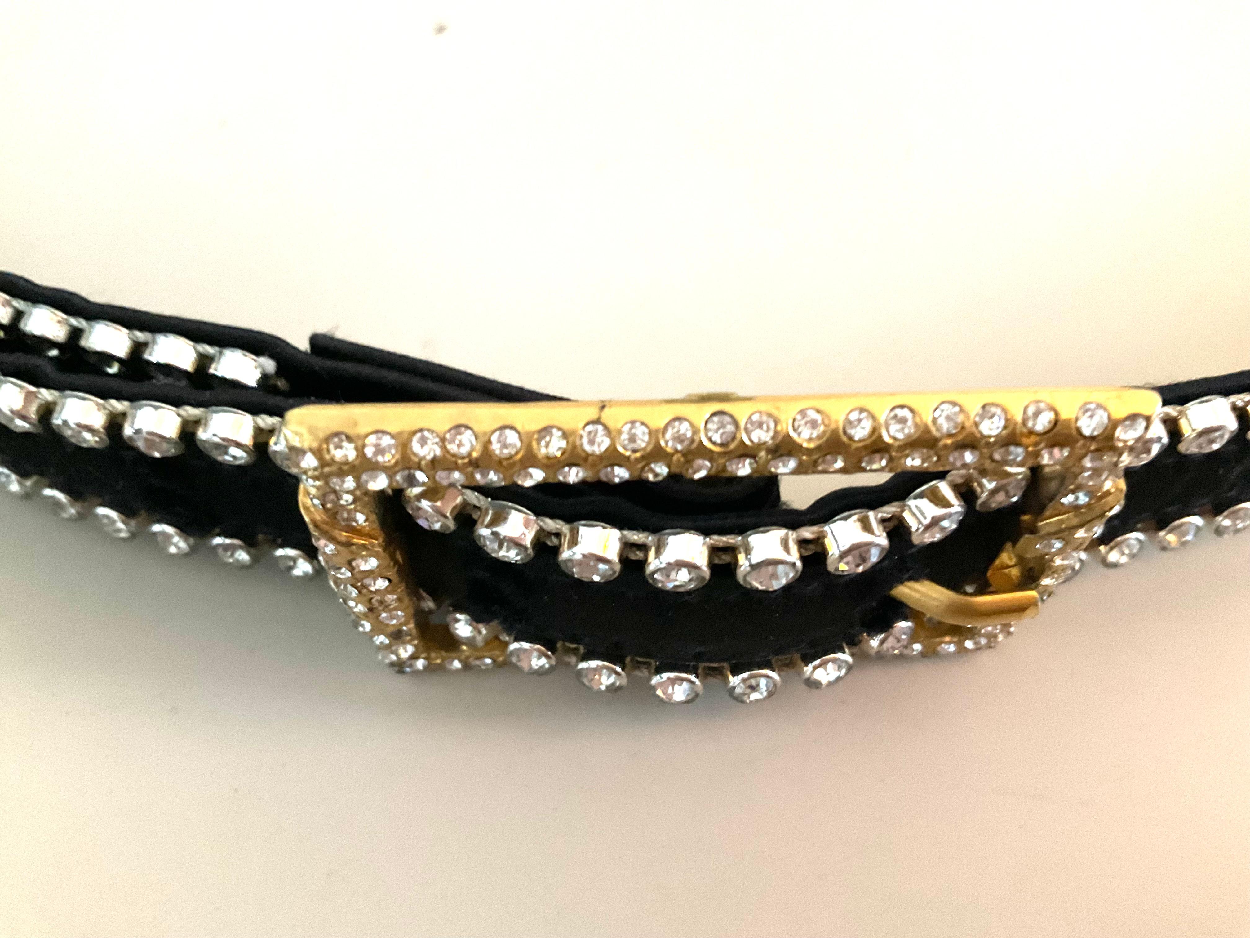 Questa rarissima cintura nera Istante by Versace con strass, in condizioni pari al nuovo, è un pezzo lussuoso e altamente collezionabile della linea più accessibile della casa di moda italiana, Istante, creata sotto la visione di Gianni Versace tra