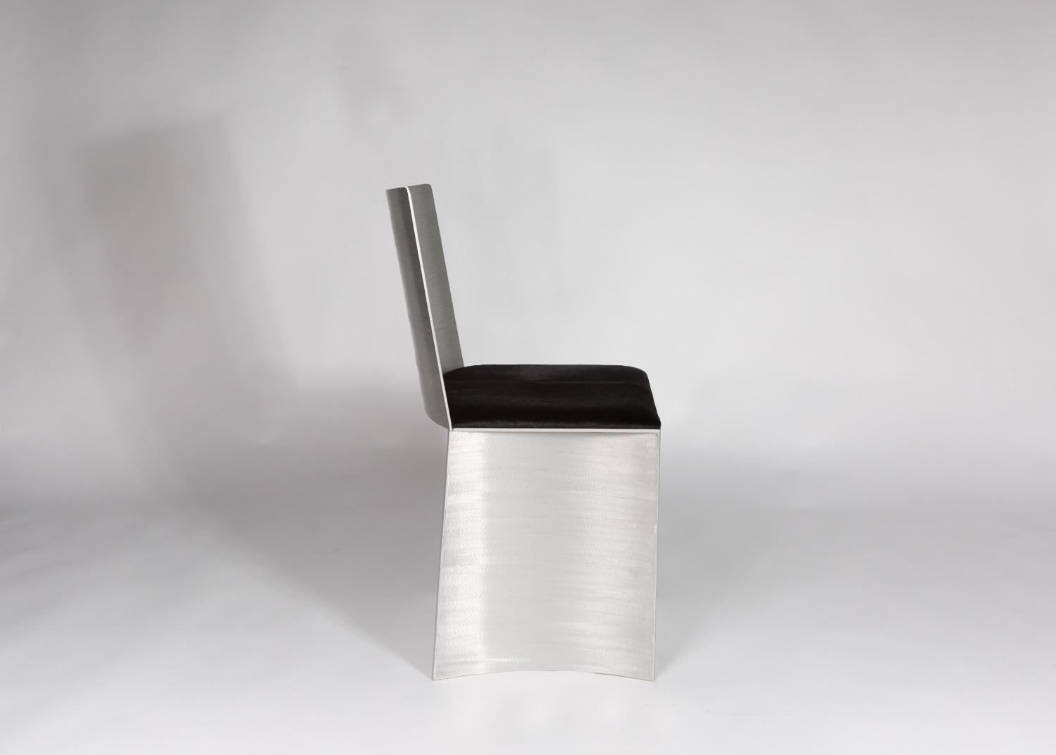 Der ISU Lowback Stuhl hat eine handgefertigte, satinierte, strukturierte Metalloberfläche, die bei Lichteinfall glänzt. Das 1,50-Zoll-Sitzkissen ist ein glänzendes schwarzes Haar auf Leder. 
COM wird nach Genehmigung akzeptiert.
Die perfekte