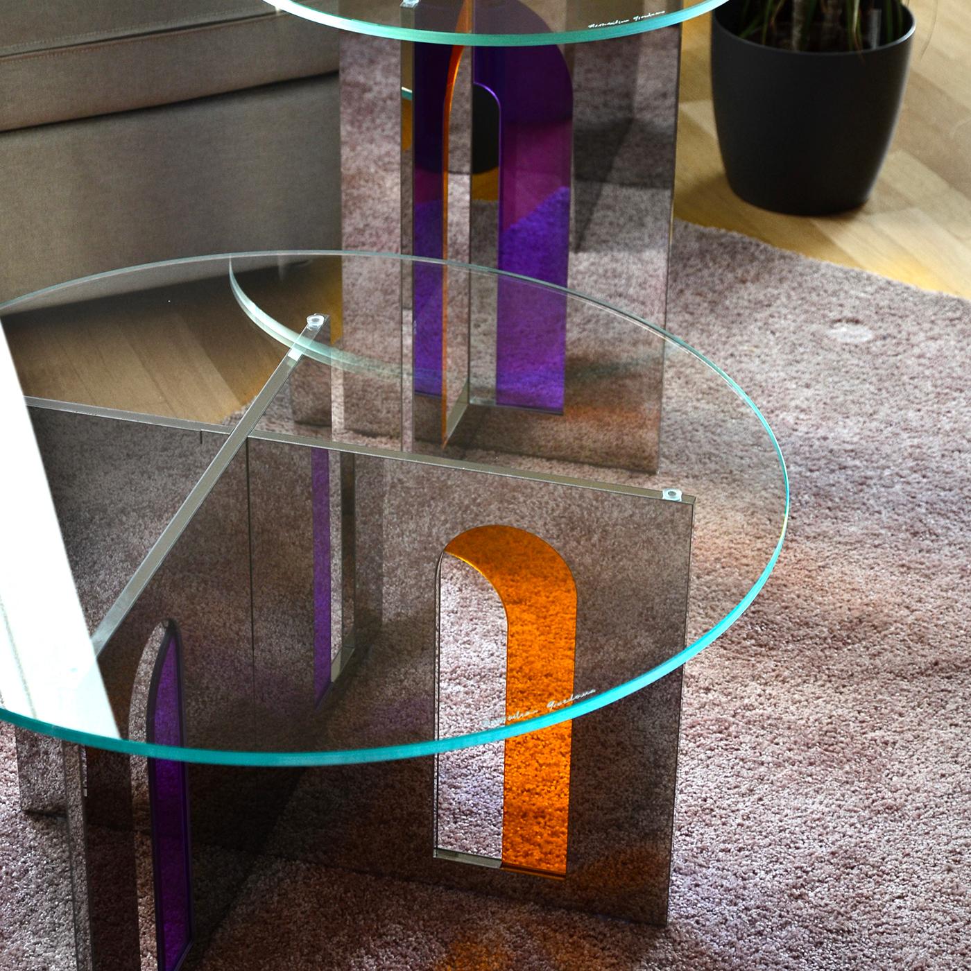 The geometries of the Itaca coffee table invite you to a journey without a destination, or rather where encounters, experiences and adventures are themselves the destination. The combination of the mirror steel surfaces and the colored glass inserts