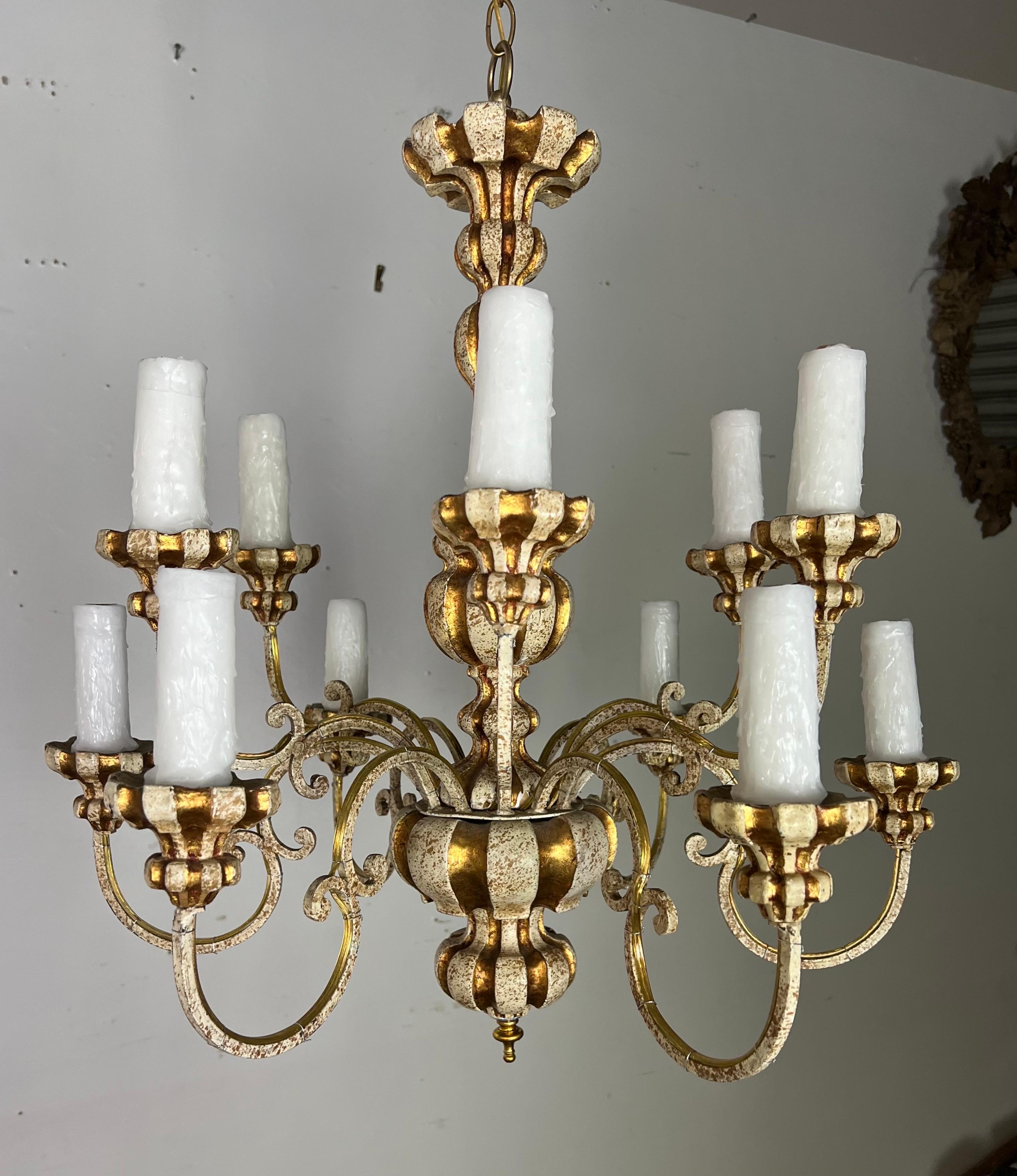 Lustre italien à 12 lumières de style rococo des années 1930.  Il présente une finition peinte en crème avec des accents de feuilles d'or. Le lustre a été récemment recâblé et comprend la chaîne et le baldaquin.