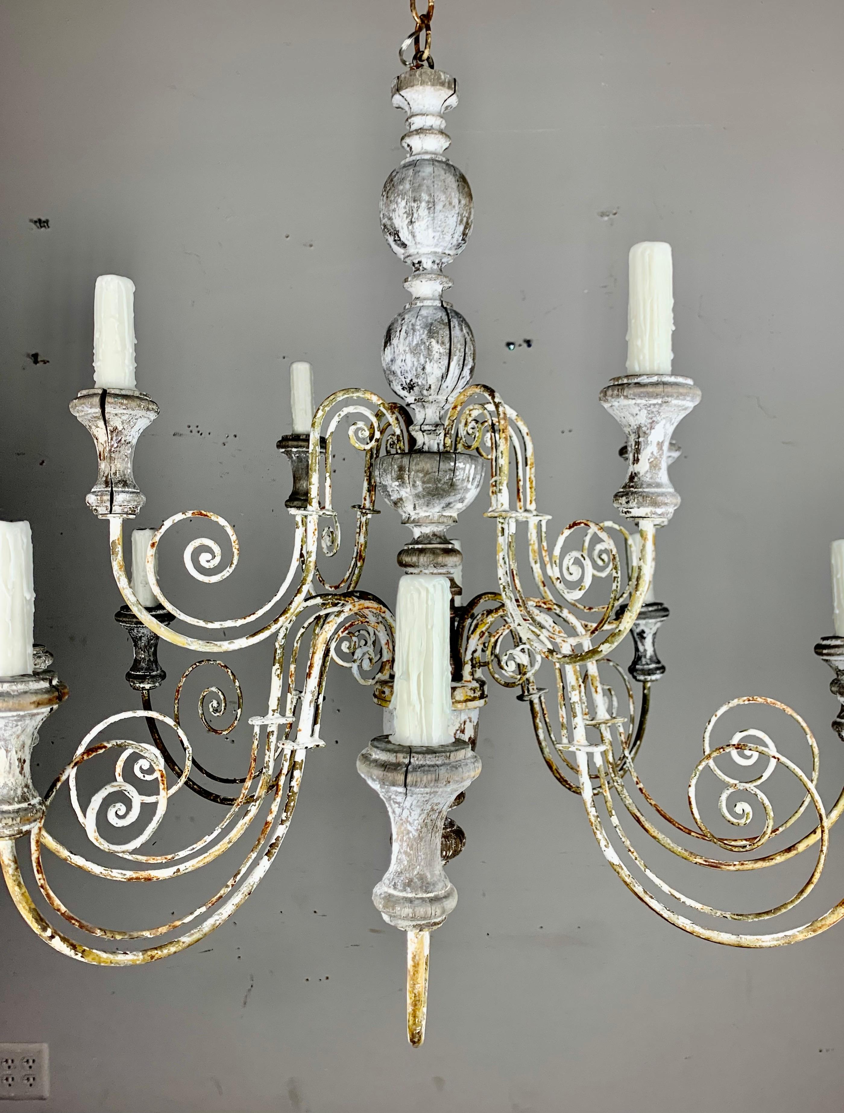Large scale Italian painted wood and scrolled wrought iron chandelier. The fixture is beautifully worn with all of it's imperfections. The chandelier is newly rewired with drip wax candle covers and includes chain & canopy.