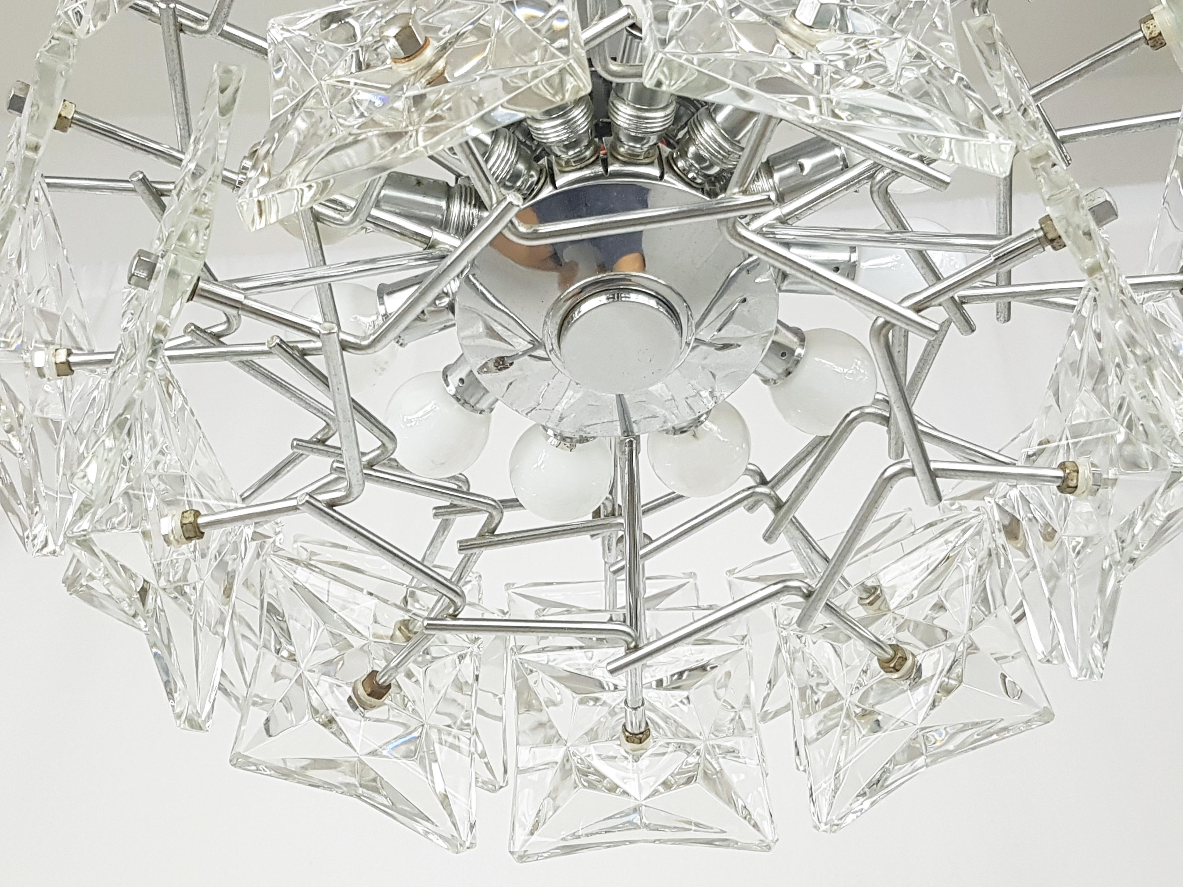 This beautiful chandelier is made of a Chrome plated metal structure equipped with 12 lamps (sockets E14) and is covered by 36 faceted glass shades distributed on 3 levels.
Very good vintage condition: normal oxidation on the plating, mostly