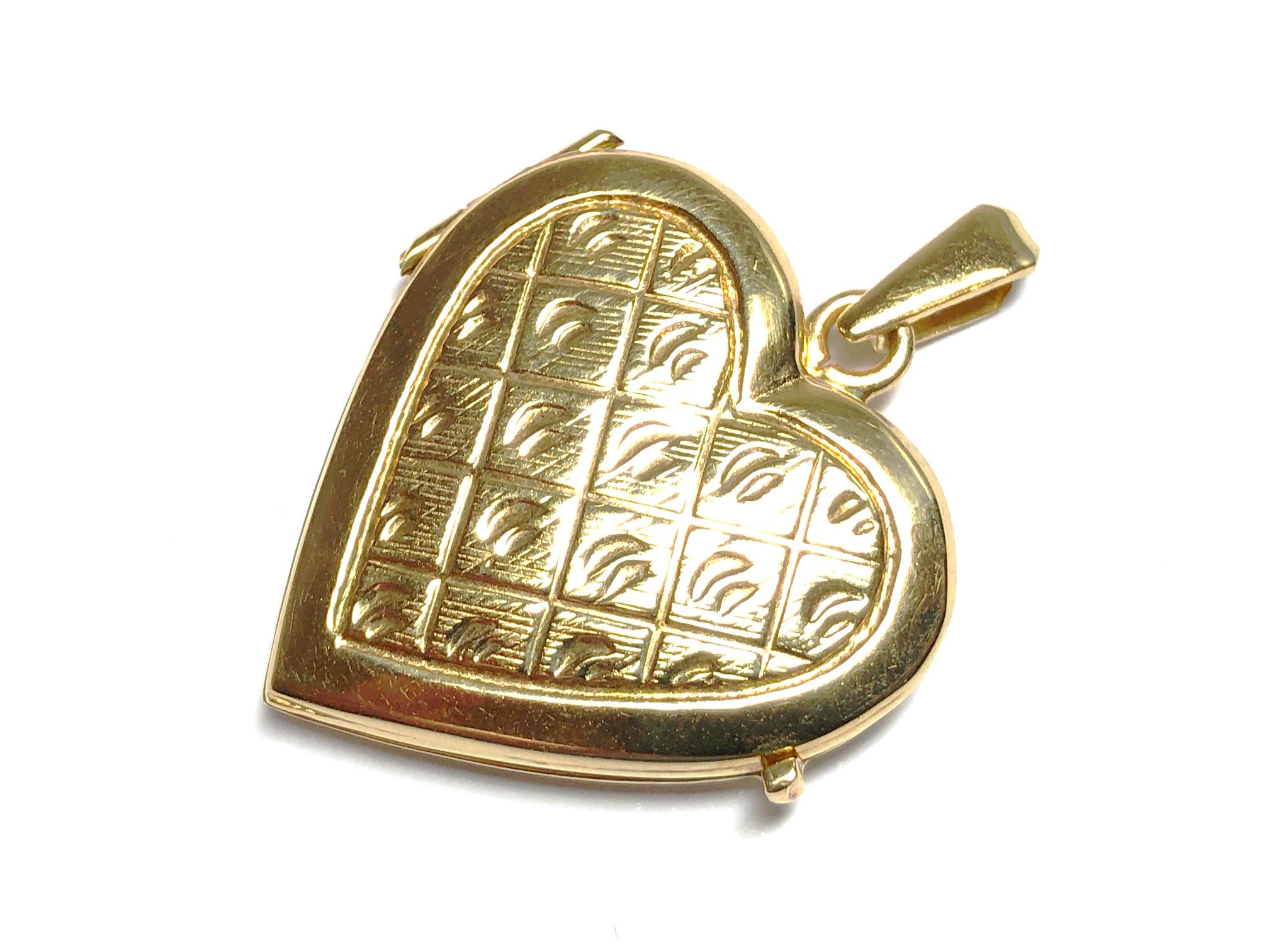 An Italian 14ct yellow gold heart locket, with an engraved quilted design, opens to hold two pictures, measures 38 x 30mm including bail, circa 1980.