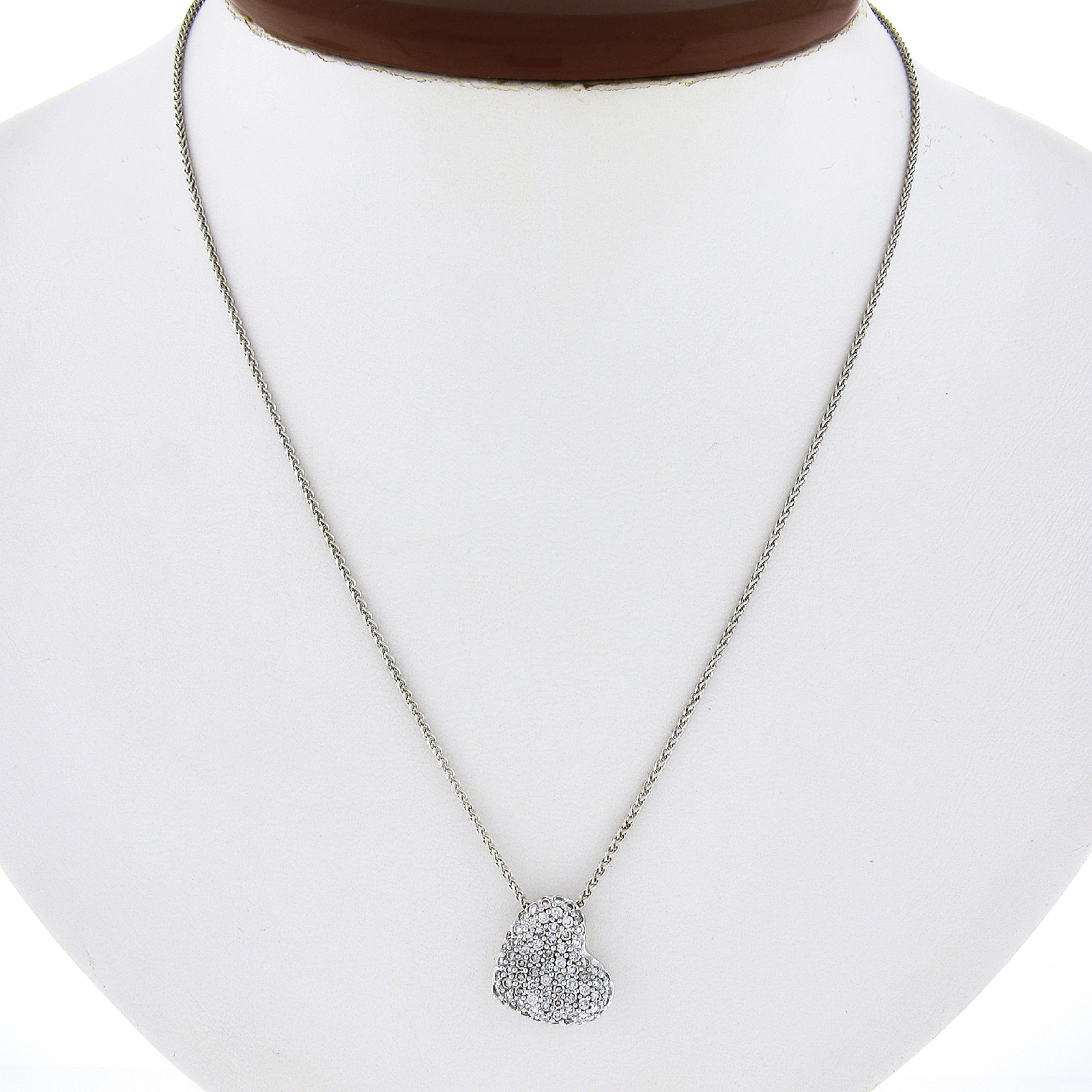 Questa splendida collana con ciondolo a cuore di diamanti è stata realizzata in oro bianco massiccio 14 carati ed è impreziosita da diamanti di alta qualità. Il cuore è leggermente concavato e a cupola in alcune parti ed è interamente ricoperto di