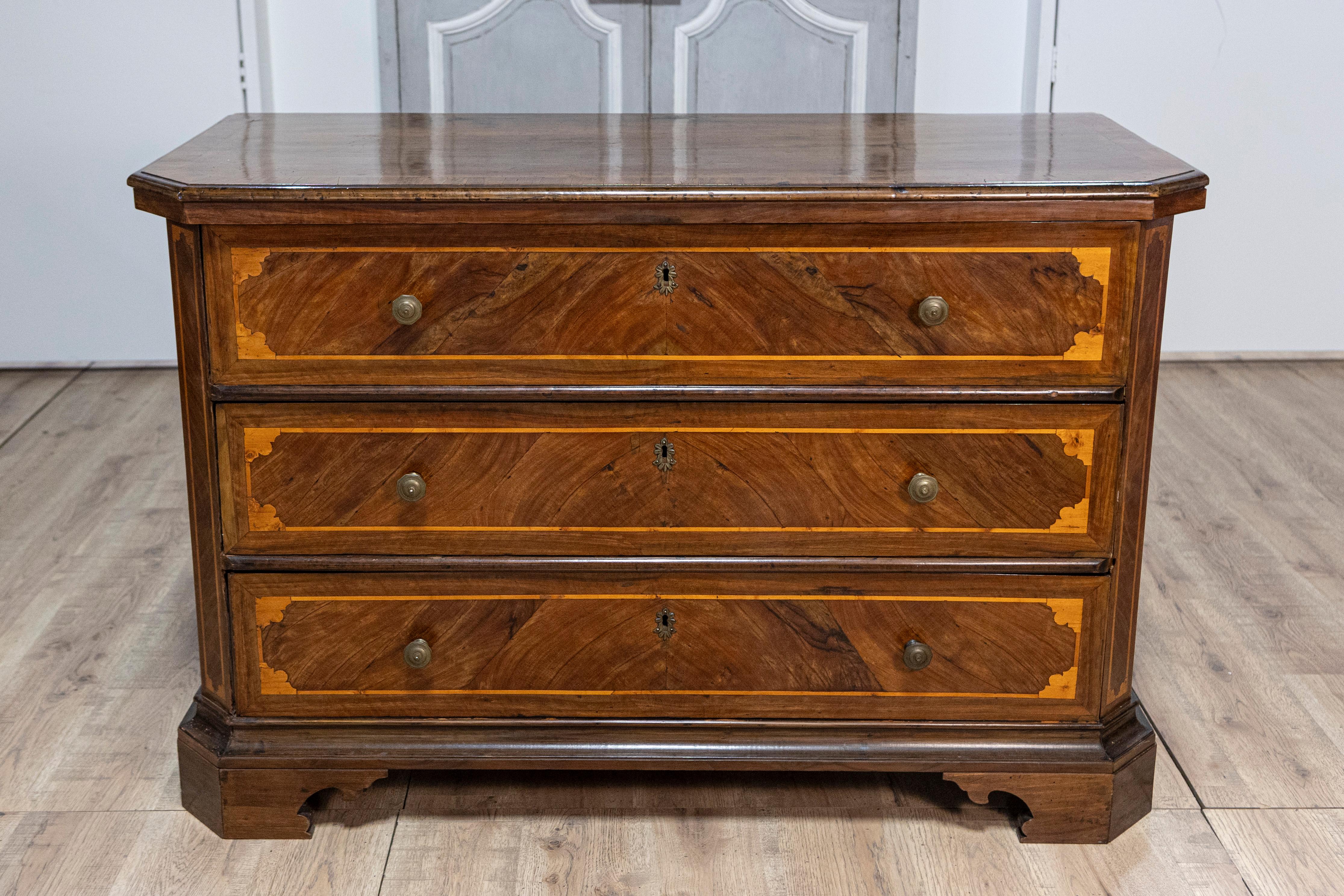 Italienische Kommode aus Nussbaum und Esche mit drei Schubladen aus der Zeit um 1690, mit eingelegtem Dekor, schrägen Seitenpfosten und eckigen Klammerfüßen. Diese exquisite italienische Kommode aus Nussbaum und Esche mit drei Schubladen aus der