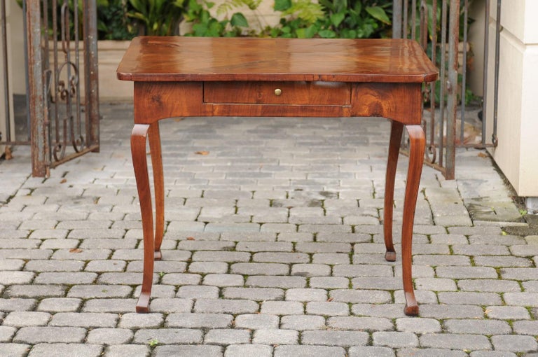 An Italian walnut quarter-veneered side table from the late 18th century, with single drawer and cabriole legs. Born in the later years of the 18th century, this Italian walnut table features an exquisite quarter-veneered top with rounded edges,