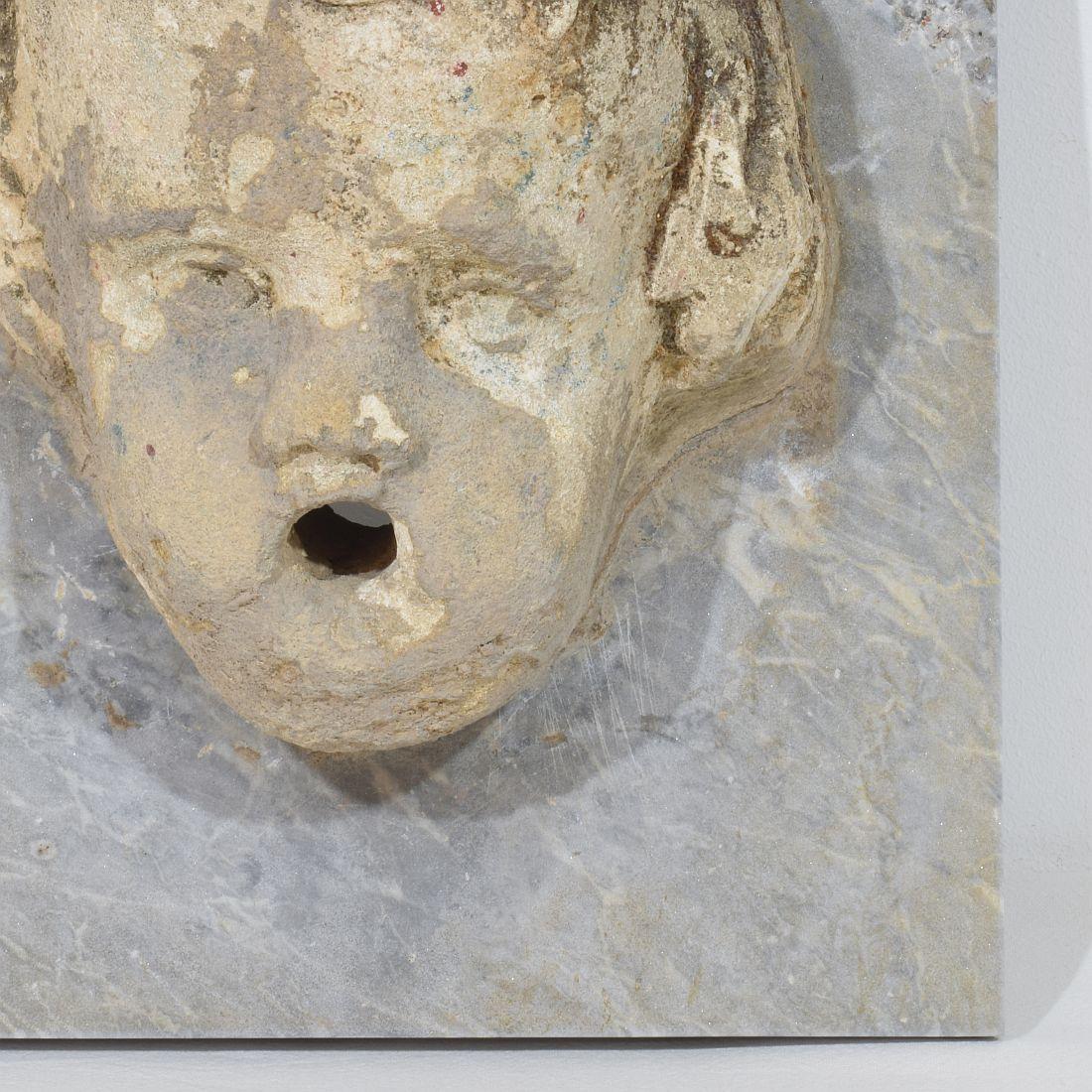Fino al XVIII secolo Testa di fontana di cherubino in pietra intagliata del XVII-XVIII secolo su pannello di marmo in vendita