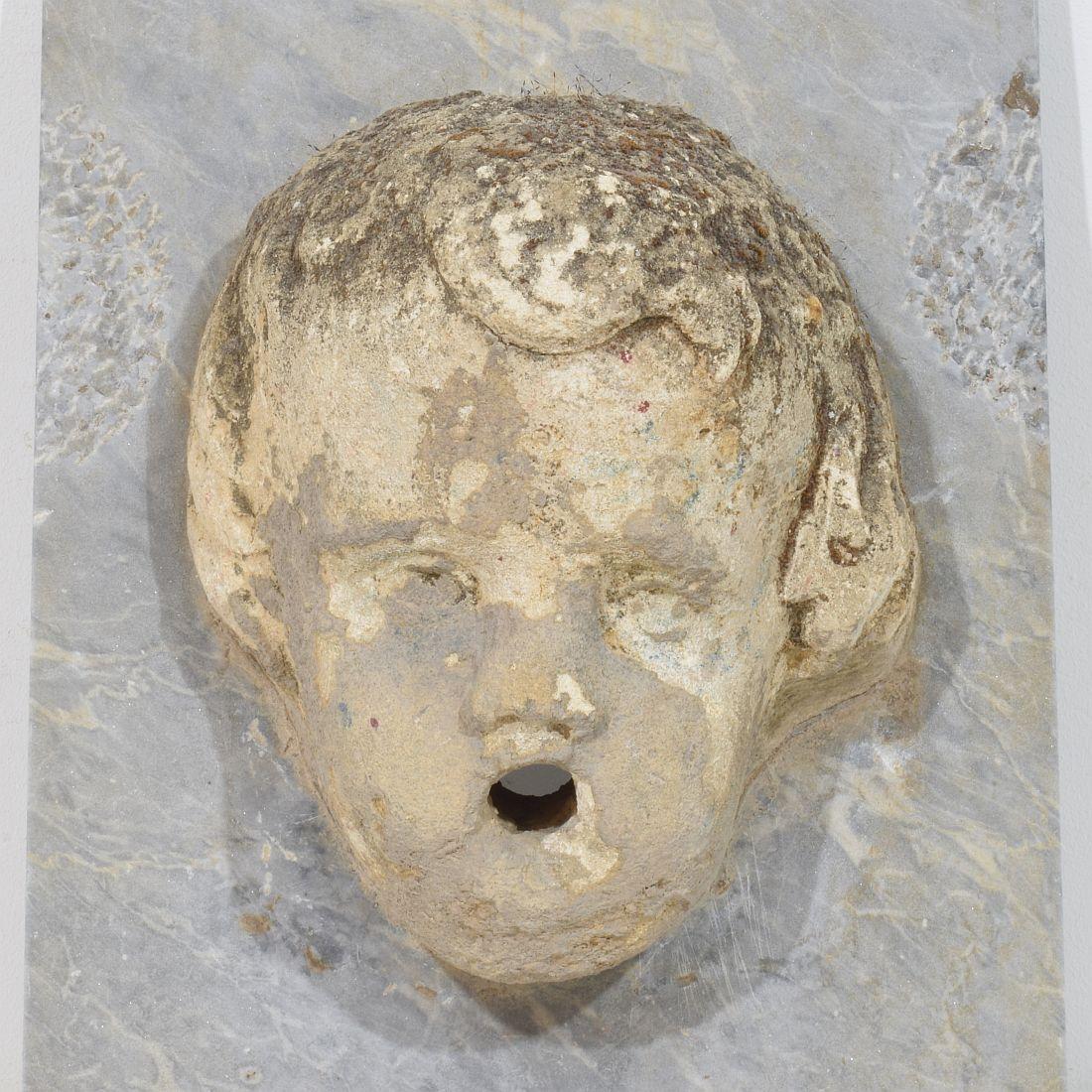 Pietra Testa di fontana di cherubino in pietra intagliata del XVII-XVIII secolo su pannello di marmo in vendita