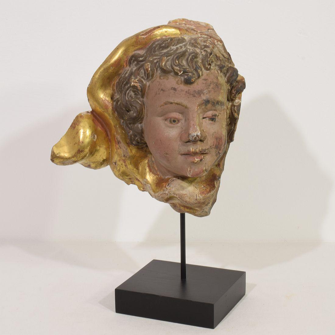 Beautiful handcarved angelhead fragment
Italy, circa 1650-1750
Weathered small losses and old repairs. 
Measurement here below inclusive the wooden base.