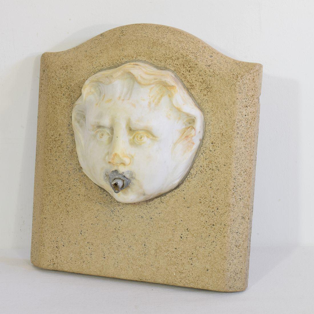 Spectacular and unique Carrera marble fountain head on stone plate of later date.
Italy, circa 1650-1750
Weathered, small losses and old repairs.
    