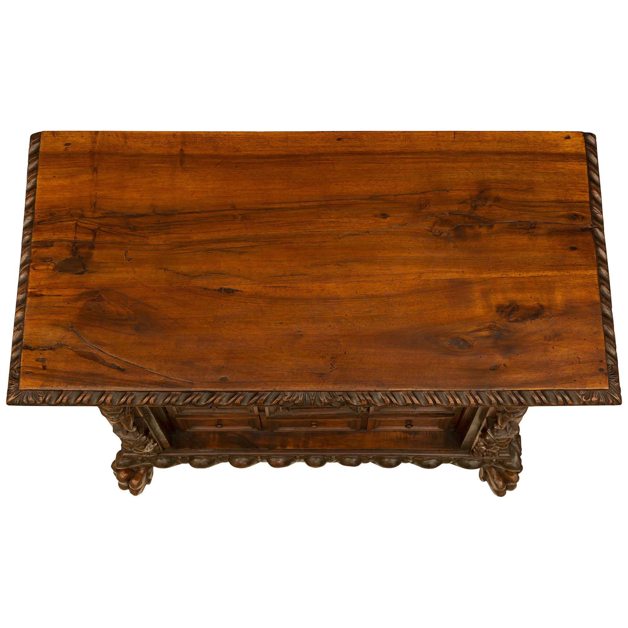 A handsome Italian 17th century Baroque period Walnut and burl Walnut cabinet. The smaller scale one door twelve drawer table top cabinet is raised by impressive paw feet below a large gadroon designed wraparound band. At the center is a single