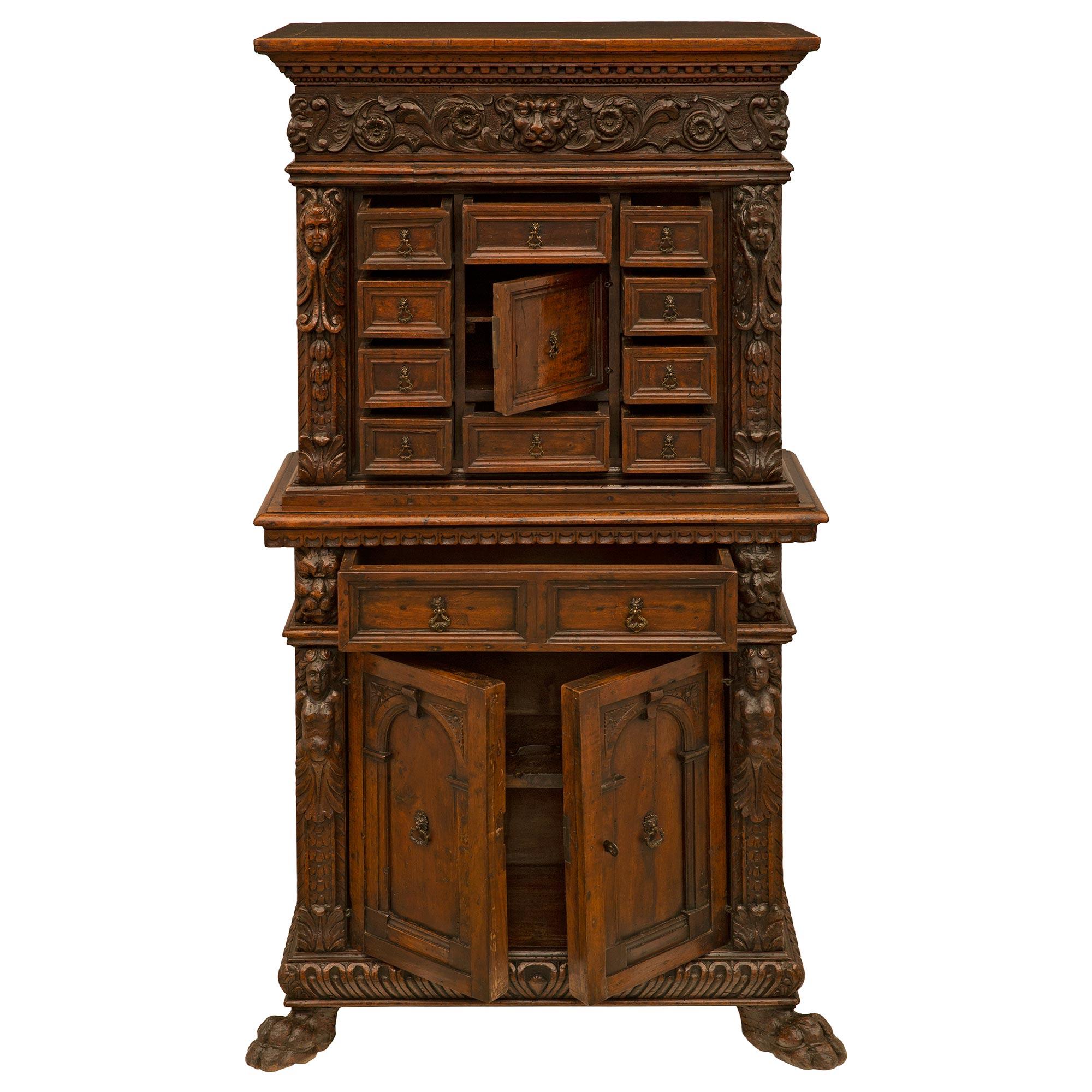 A handsome Italian 17th century Baroque period Walnut and iron specimen cabinet. The three door eleven drawer cabinet is raised by impressive paw feet below a mottled border with a striking reeded gadroon like design. At the center are two doors