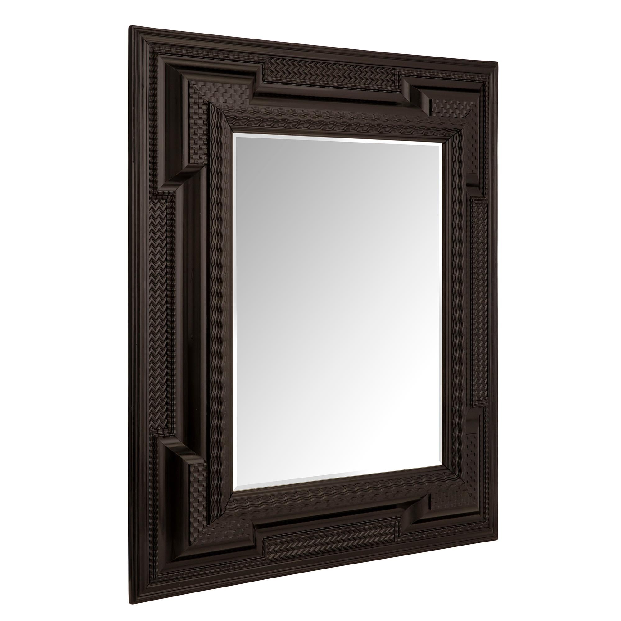 A beautiful and most impressive Italian 17th century ebony Florentine mirror. The original beveled mirror plate is framed within a handsome thick ebony border. The border displays unique finely carved wave like patterns spread over the most