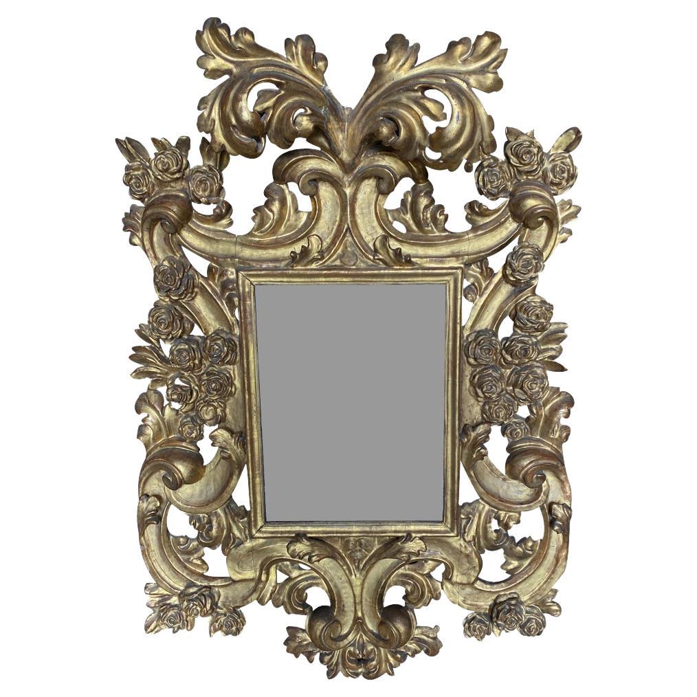 Superbe miroir italien du 17ème siècle en or doré provenant de la région de Gênes en Italie. Fabriqué de manière experte avec des détails de sculpture exquis de magnifiques roses. Le miroir conserve son verre d'origine. Exceptionnel.