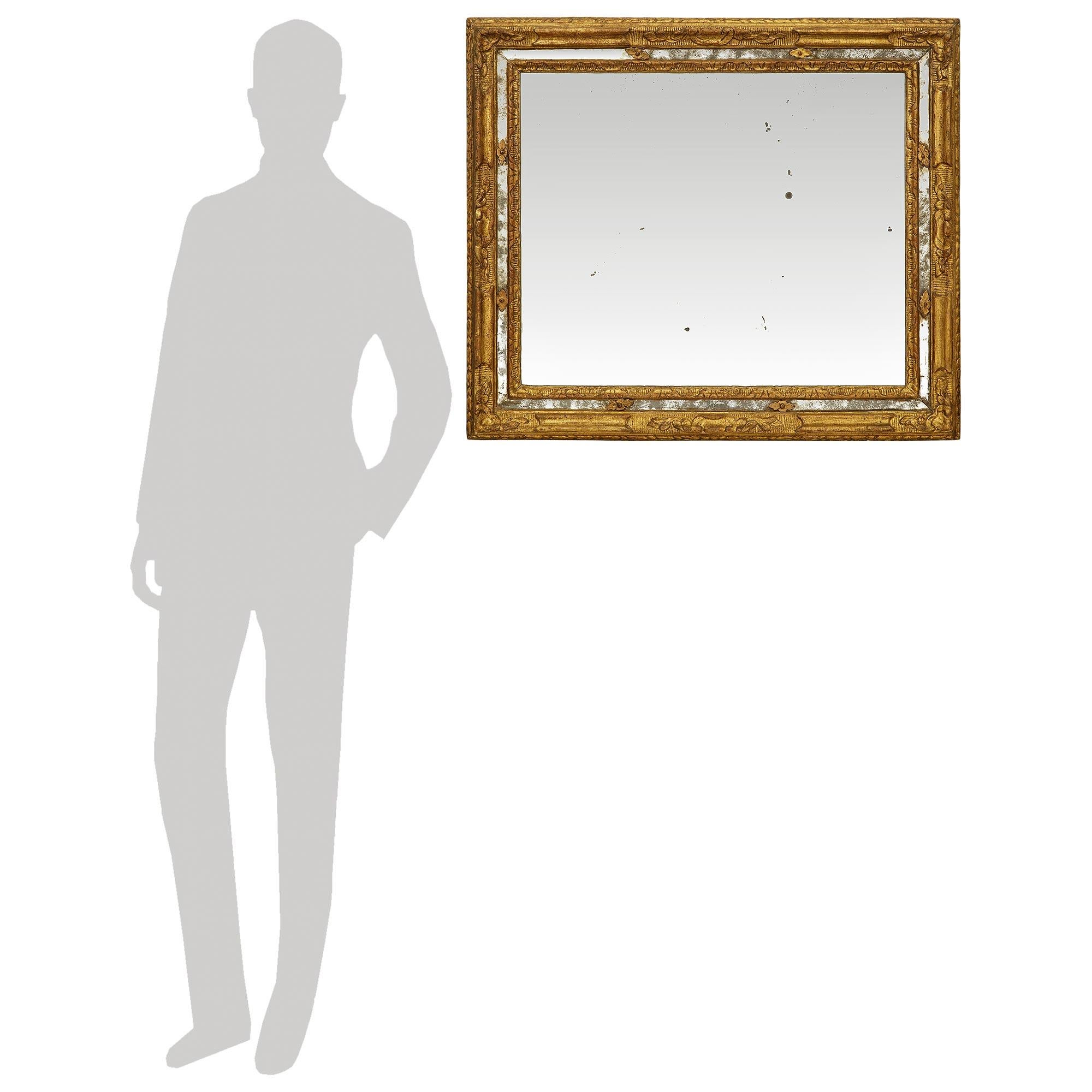 Magnifique et très élégant miroir italien en bois doré d'époque Louis XIV du XVIIe siècle. Ce superbe miroir à double encadrement présente un cadre feuillagé finement sculpté avec un design cannelé. Au centre de la bordure extérieure du miroir se