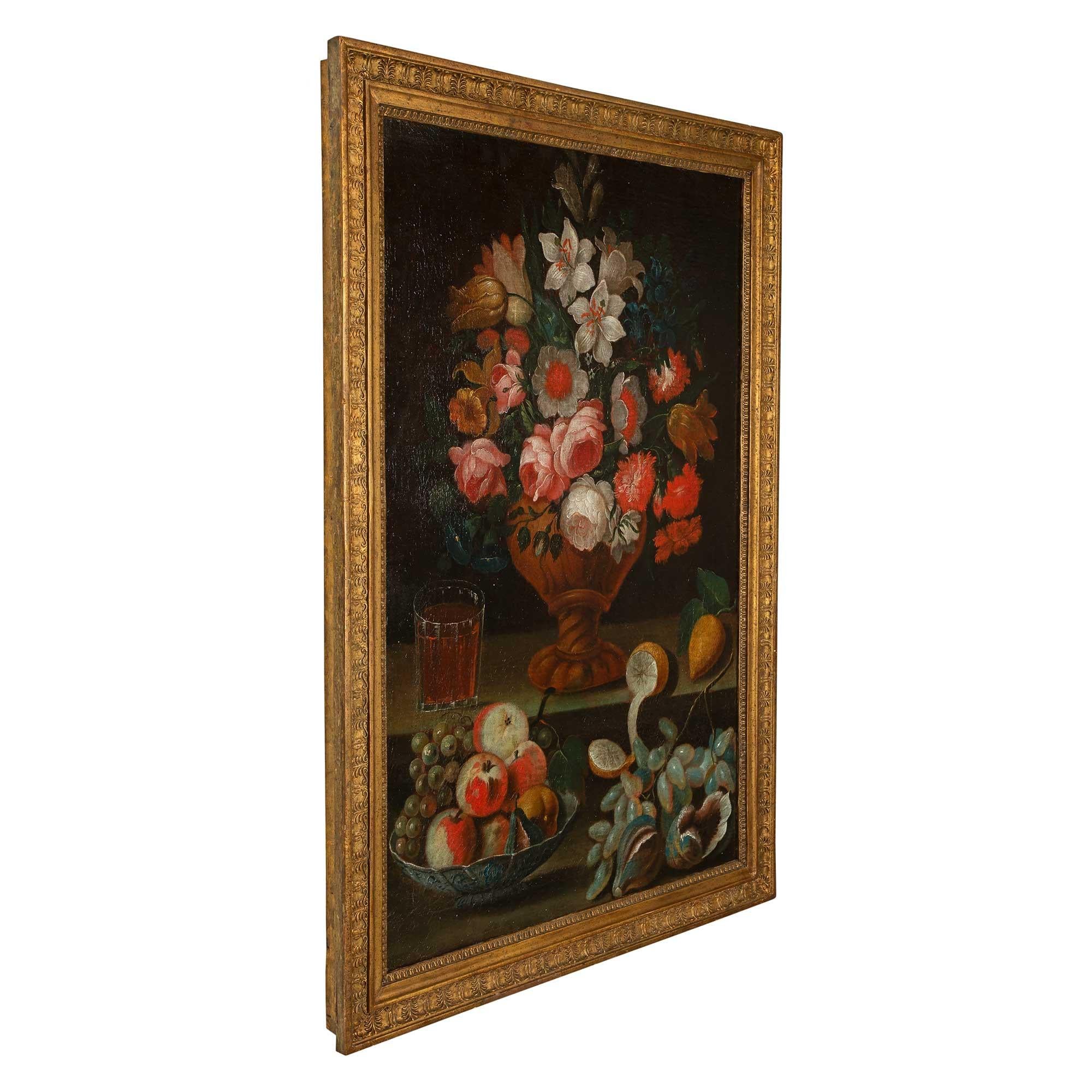 A stunning Italian 17th century oil on canvas still life, from Rome. The painting depicts a beautiful fruit bowl and grapes in the foreground and wonderfully executed bouquet of flowers with outstanding vivid colors. Next to it is a full glass of an
