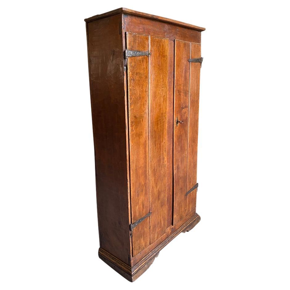 A very handsome 17th century Armoire from Northern Italy.  Beautifully constructed from walnut and chestnut woods with 2 doors, center style, interior shelving, very handsome hardware and raised on bracket feet.  A wonderful piece for any living