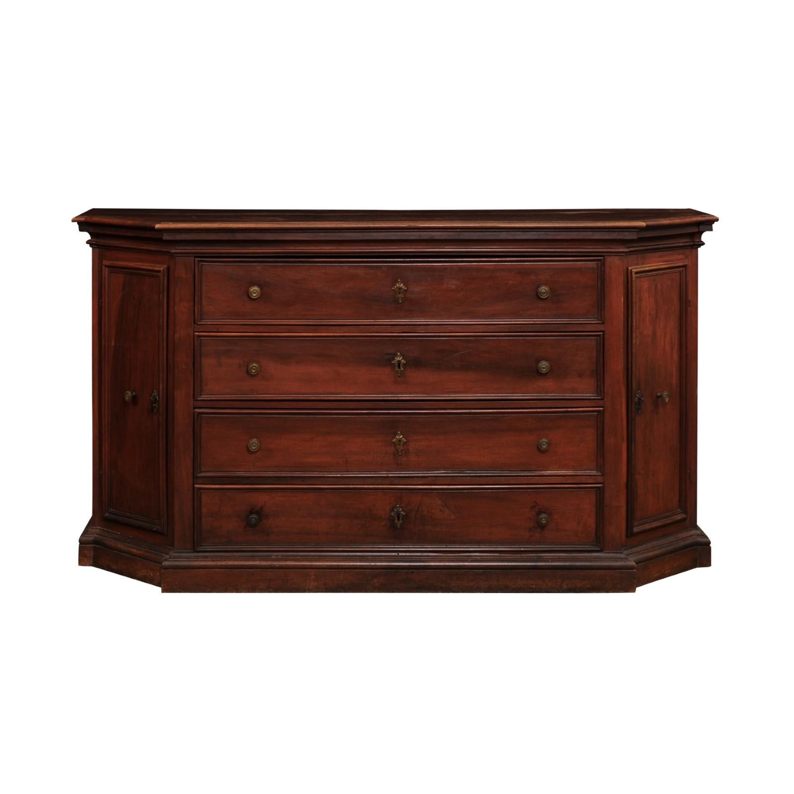 An Italian walnut dresser from the 17th century with four drawers, canted sides with doors, molded accents and rustic character. Created in Italy during the 17th century, this walnut dresser features a rectangular top with canted sides and
