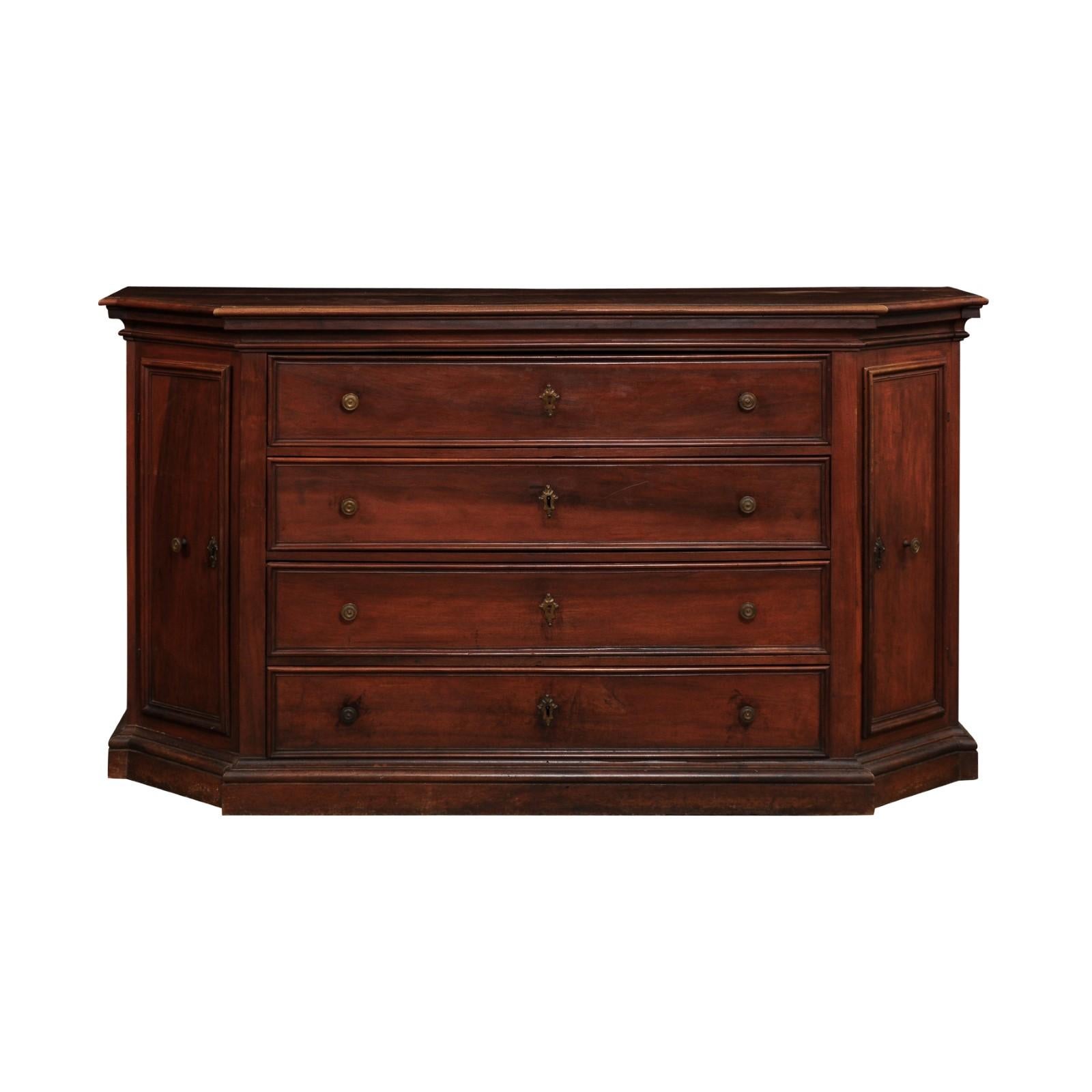 An Italian walnut dresser from the 17th century with four drawers, canted sides with doors, molded accents and rustic character. Created in Italy during the 17th century, this walnut dresser features a rectangular top with canted sides and