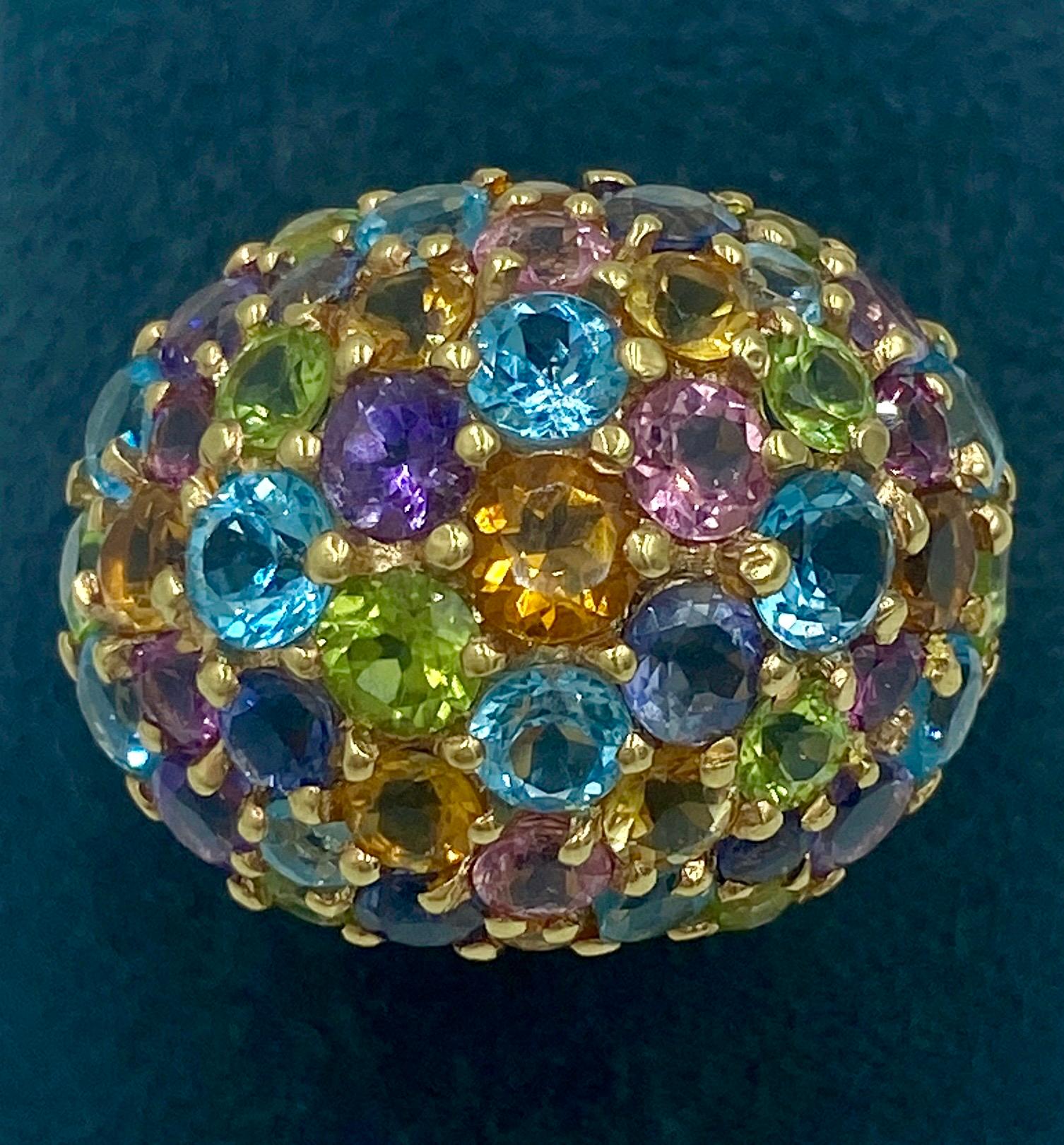 This is a delightful Italian 18 karat pink gold dome ring adorned with an assortment of gemstones including coloured sapphires, aquamarine, amethyst, peridot and  tourmaline. It is beautifully made and the multi coloured stones are a joy to behold.