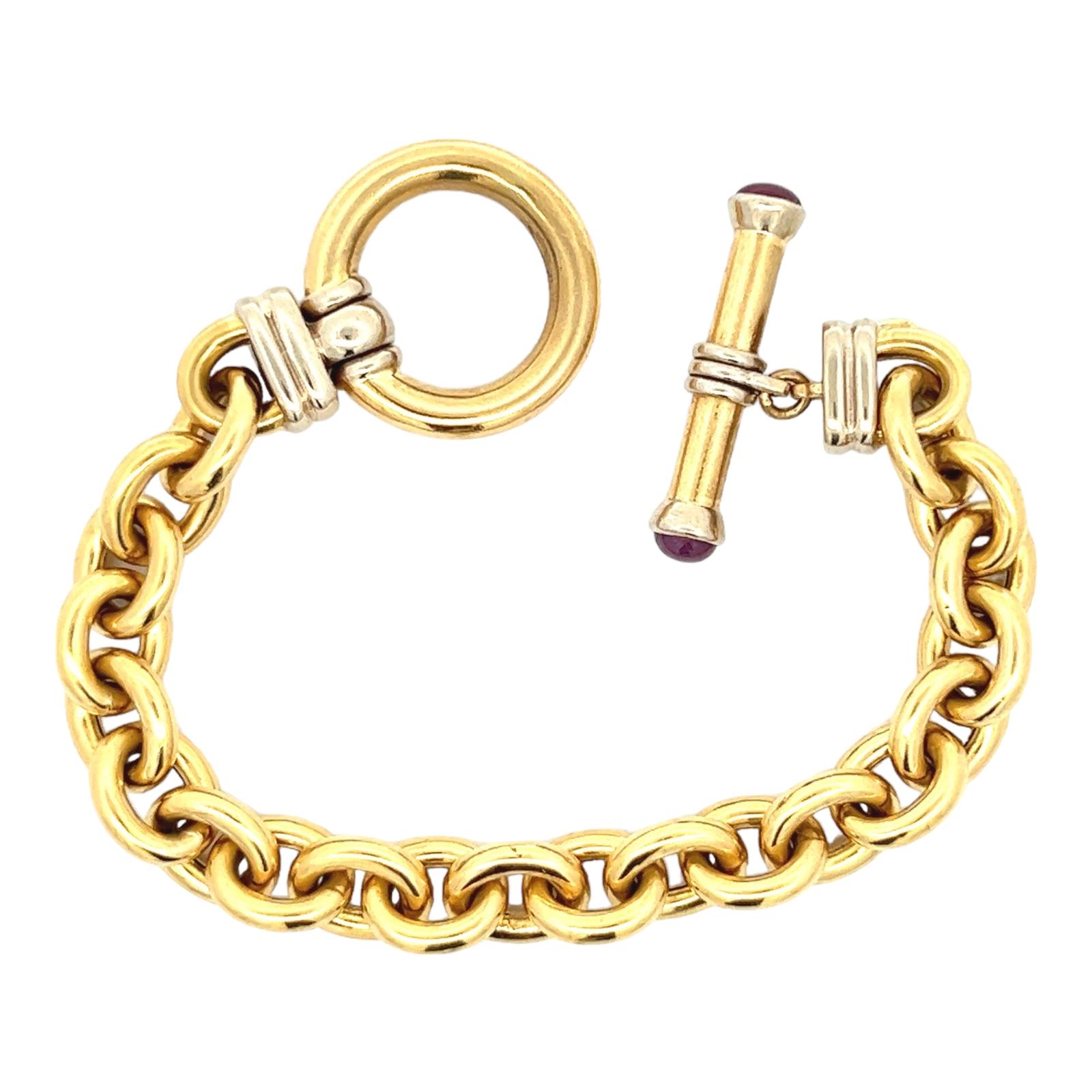 Italian modern oval link bracelet crafted in 18 karat white and yellow gold. The bracelet features a toggle clasp with cabochon ruby endpoints. The bracelet measures 7.5 inches in length and is signed Elledue Italy. 