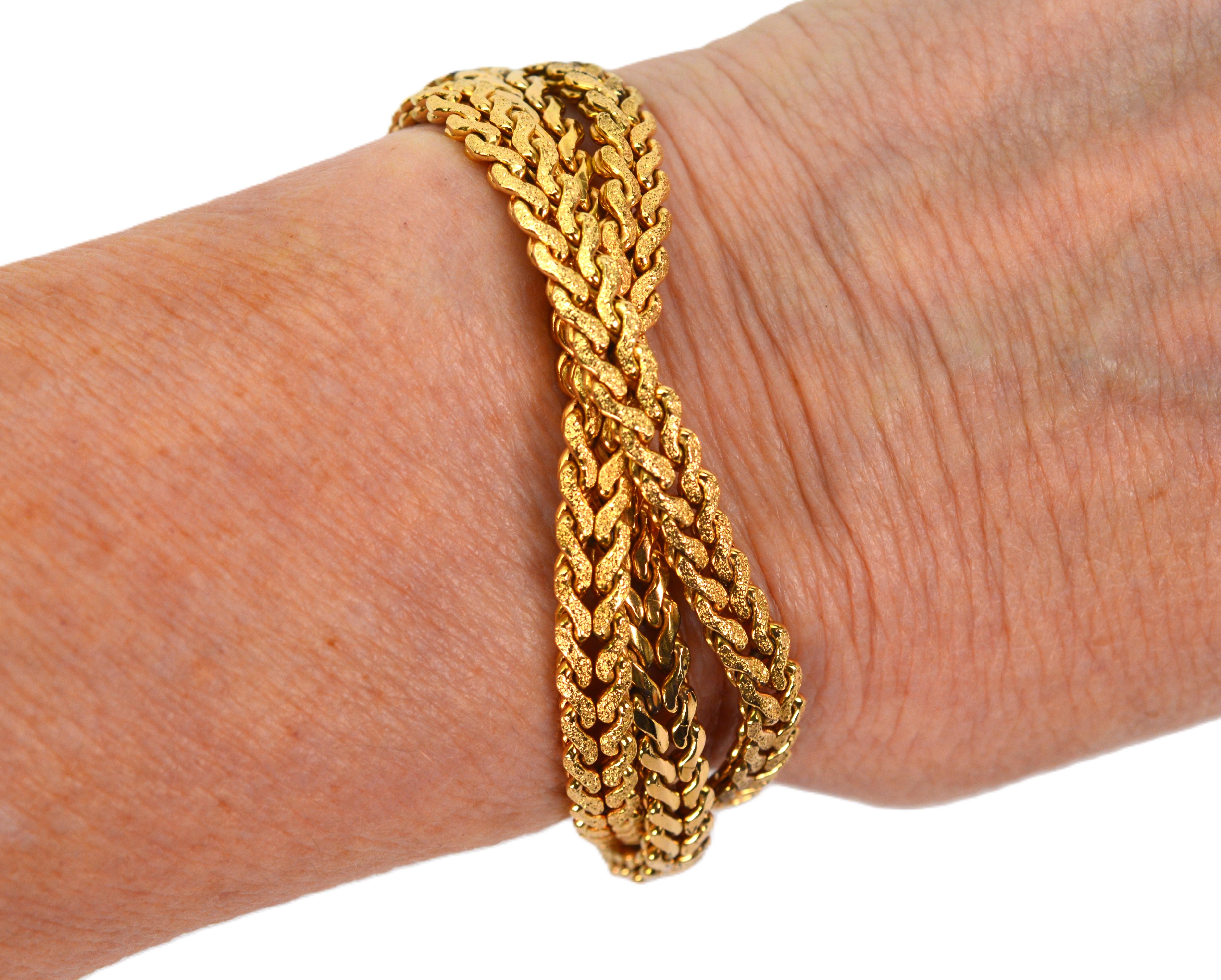 J'adore ce look ! Enveloppez votre poignet de plusieurs longueurs de chaîne à chevrons en or jaune de dix-huit carats, satinée et brillante, tressée et affichant le look de l'élégance décontractée.  Offrant confort et flexibilité, ce bracelet de