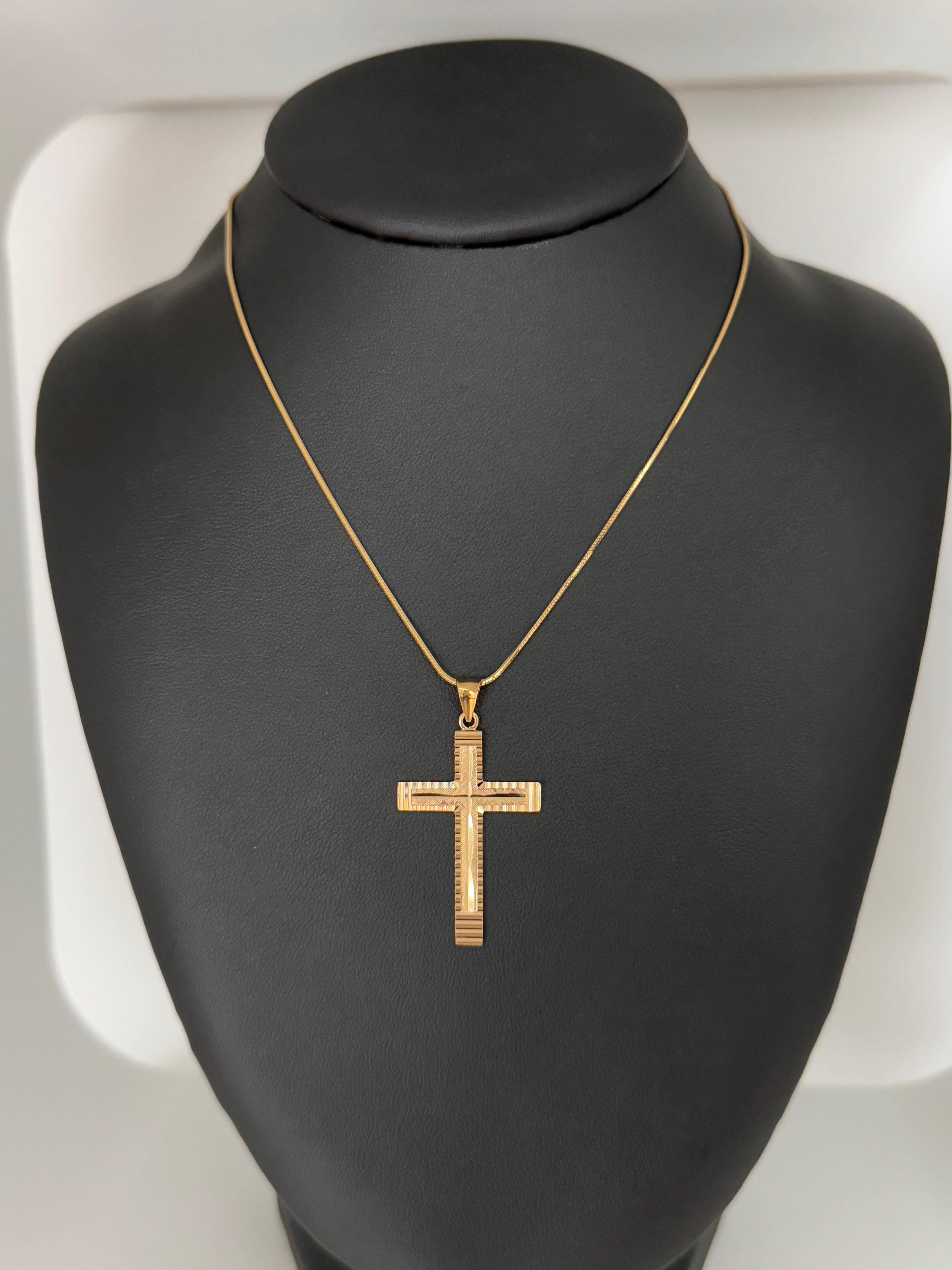 This striking Italian cross pendant, finely crafted in 18 karat yellow gold, blends classical symbolism with contemporary design elements. The cross features a satin finish that gives the gold a soft, matte glow—subtly elegant and refined—while