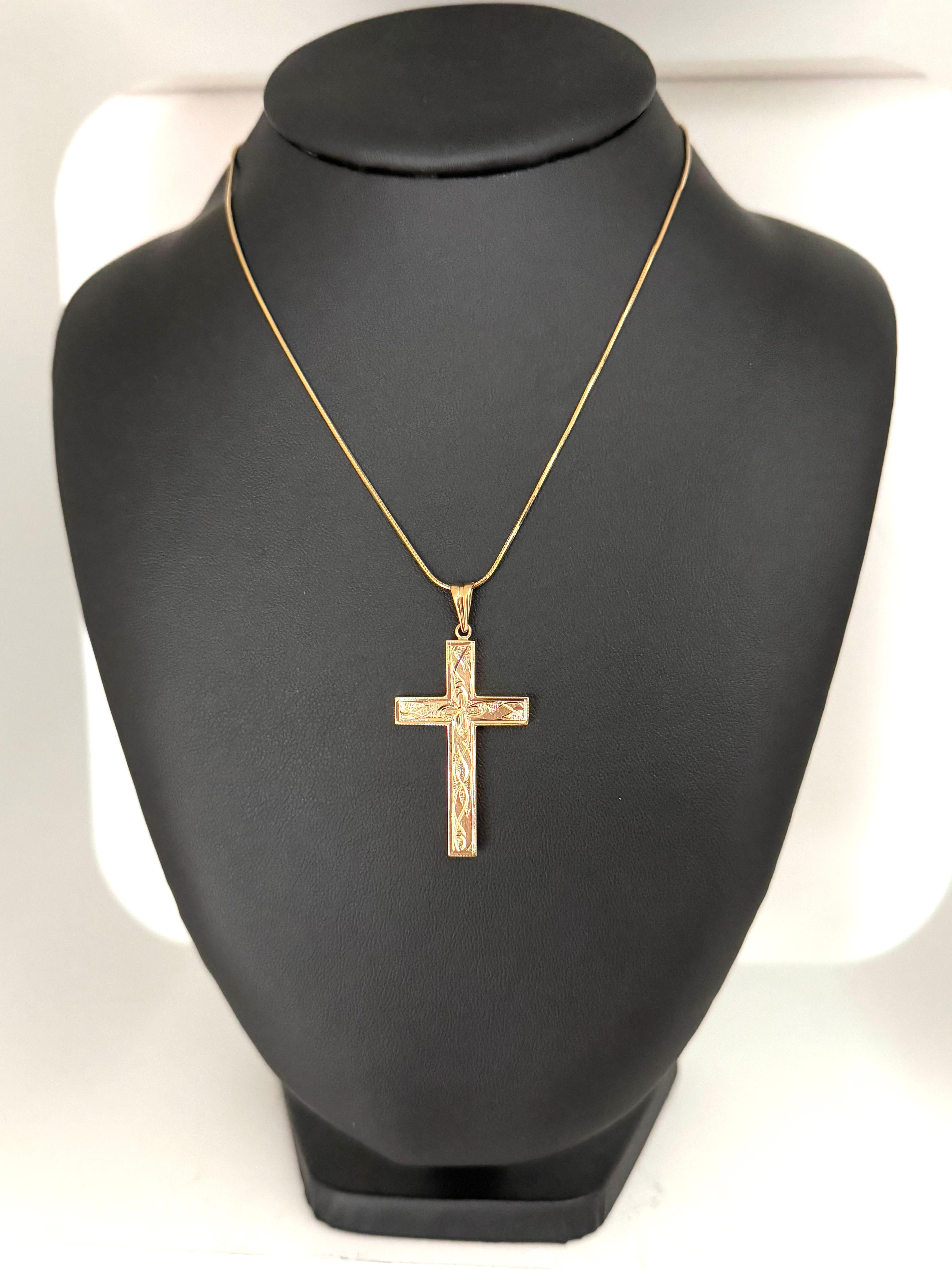 Cette croix italienne en or jaune 18 carats est une pièce magnifiquement travaillée qui allie la signification dévotionnelle au charme d'un design d'inspiration florale. Fabriquée en or jaune riche et chaud, la croix présente un élégant motif floral