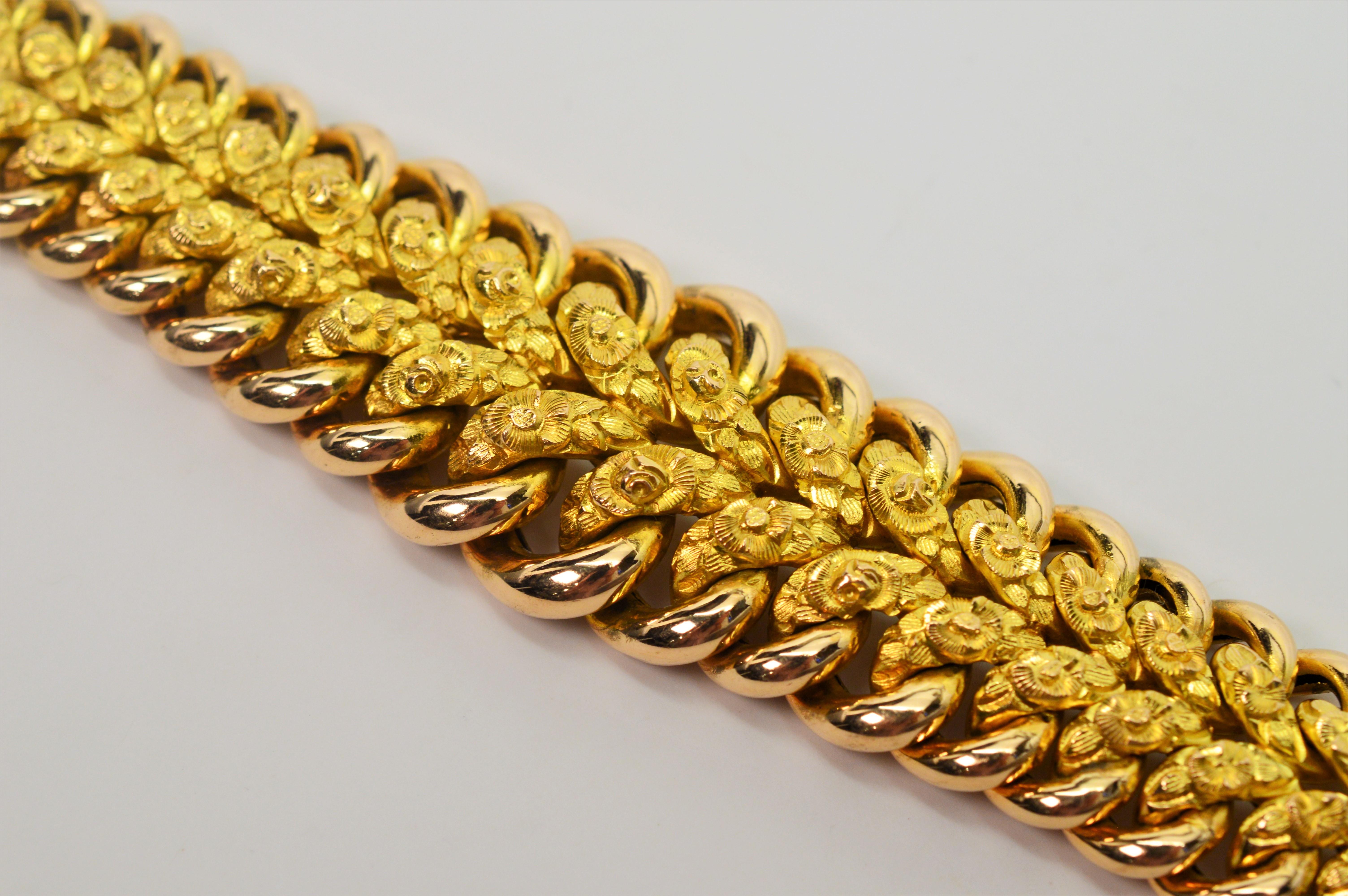 Generously sized and finely constructed in both bright and satin eighteen karat yellow gold, this fancy 1950's bracelet goes the extra mile measuring
8-1/4 inches in length. The double row of interior satin gold links have an elegant floral pattern