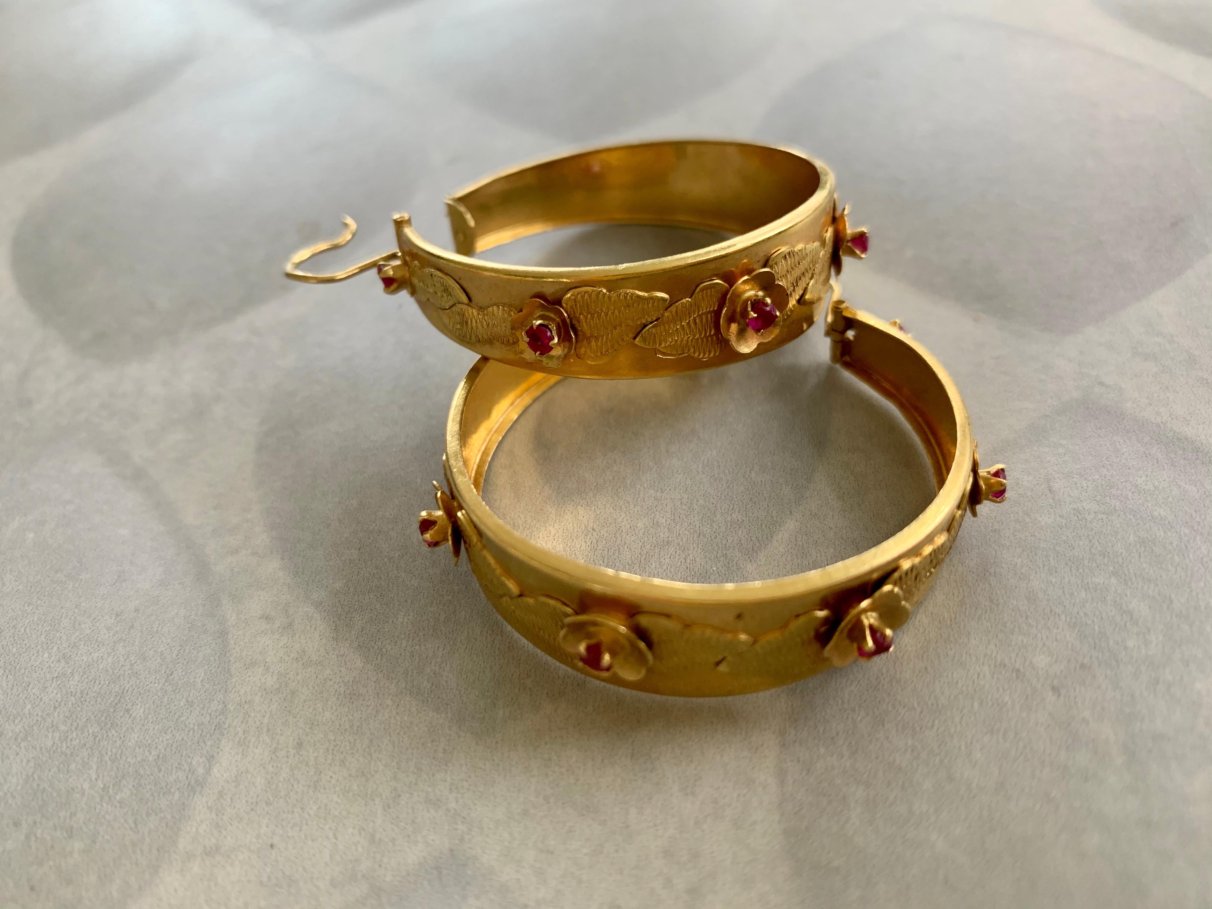 These Italian hoop earrings are 18 karat yellow Gold.  Each hoop features seven lab Ruby 2.5mm stones placed evenly around the outside of the hoop.  Each stone looks as if it is the center of a flower, with gold overlays around each which look like