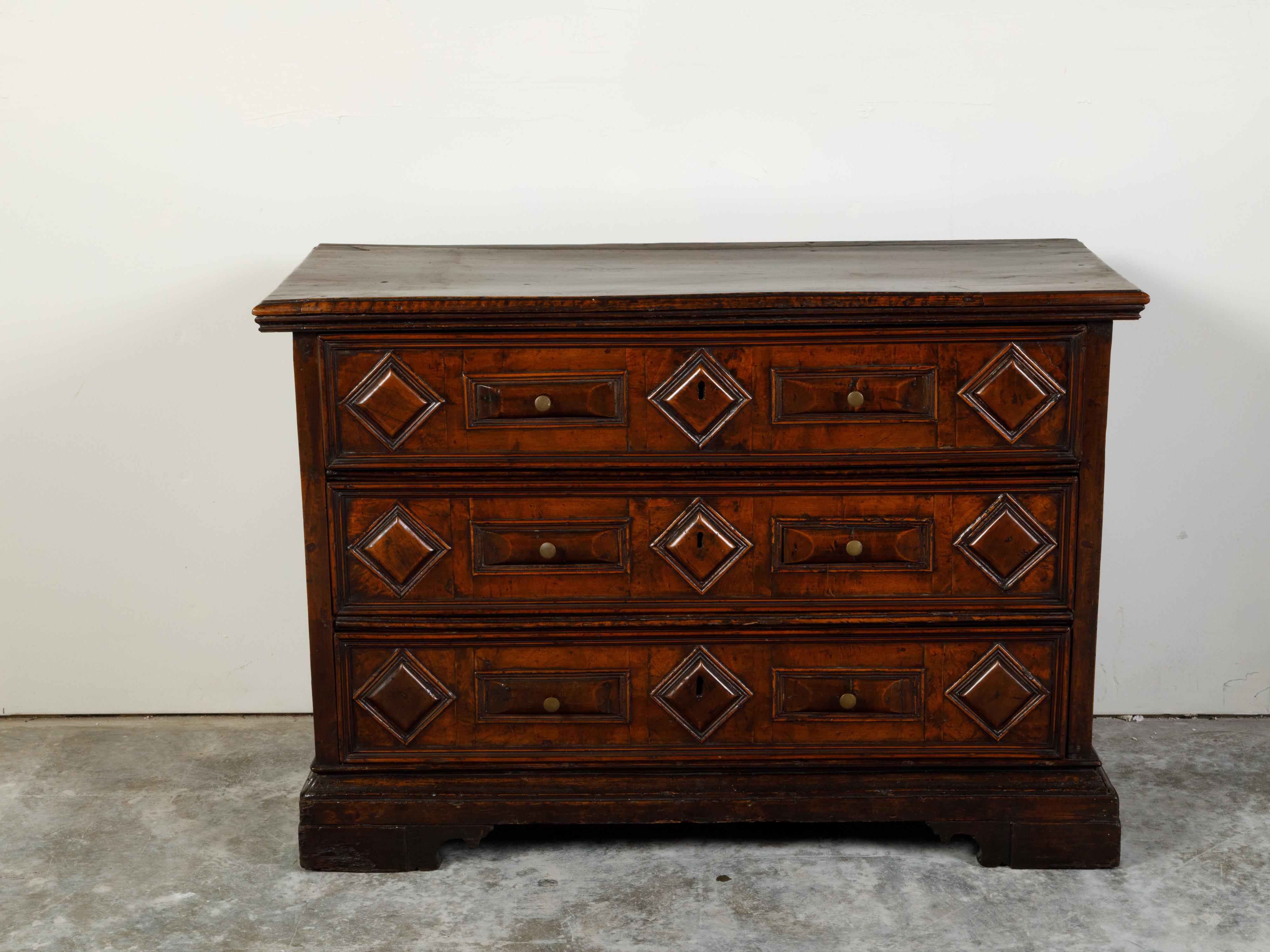 An Italian walnut commode from the early 19th century, with three drawers and raised diamond motifs. Created in Italy during the early years of the 19th century, this walnut commode features a rectangular top sitting above three drawers each adorned
