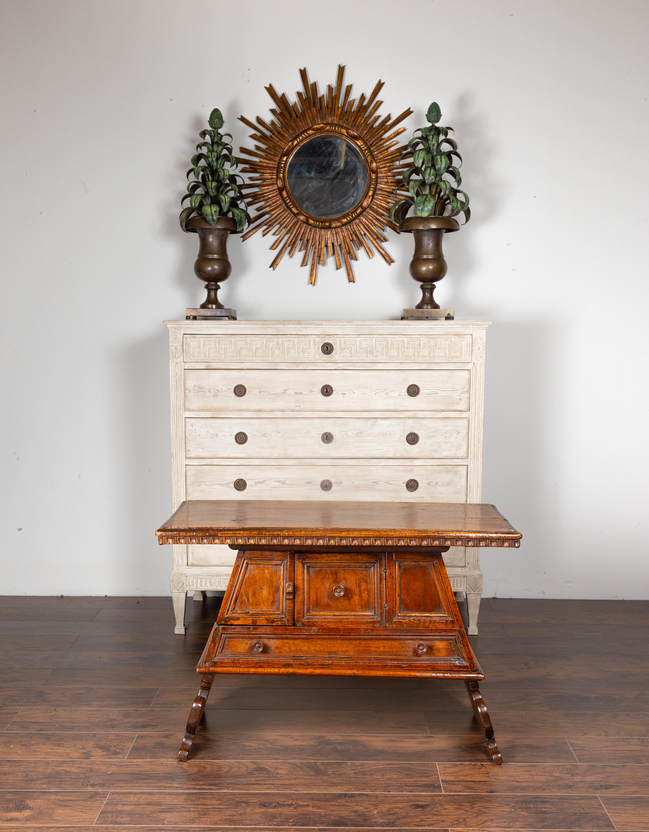 An Italian walnut console cabinet table from the early 19th century, with scoop patterns and pyramidal shape. Born in Italy during the early years of the 19th century, this exquisite walnut console features a rectangular top adorned with scoop