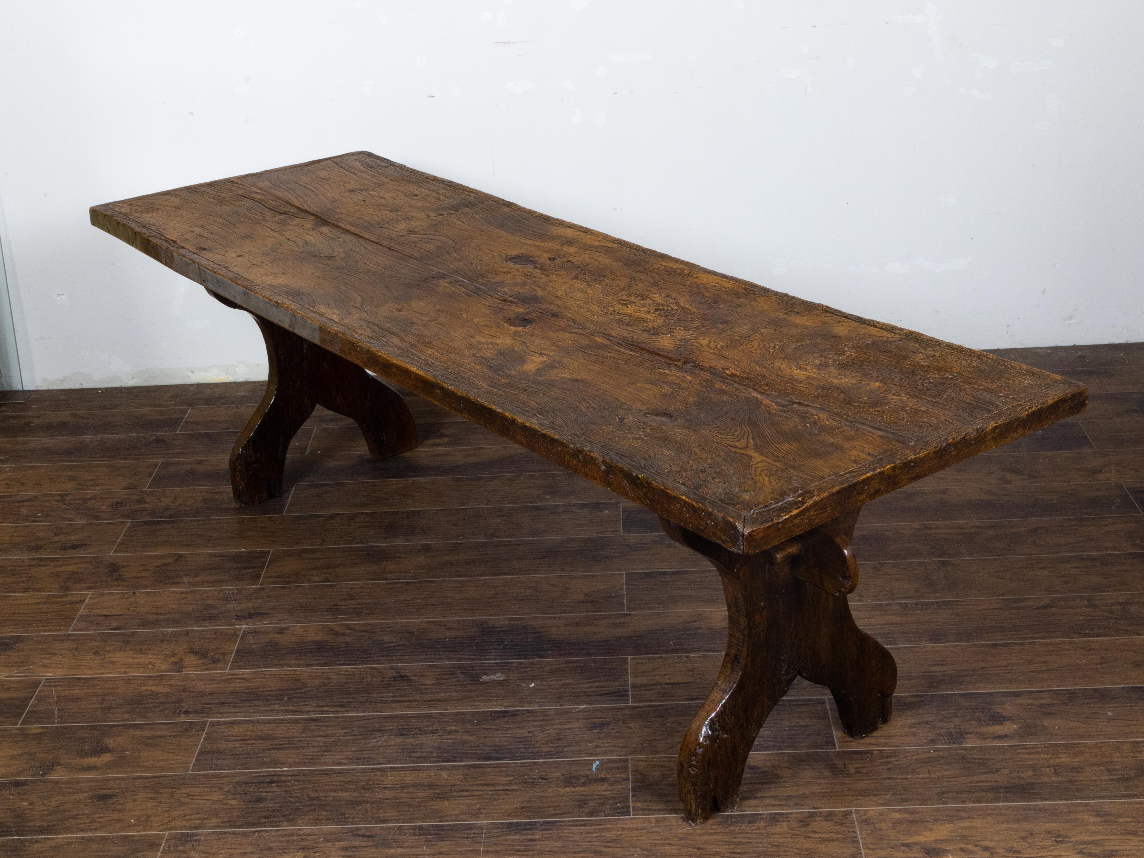 An Italian walnut farm table circa 1800 with carved legs, plain cross stretcher and nicely aged patina. This Italian walnut farm table, circa 1800, exudes a sense of rustic elegance and time-honored craftsmanship. With its beautifully aged patina