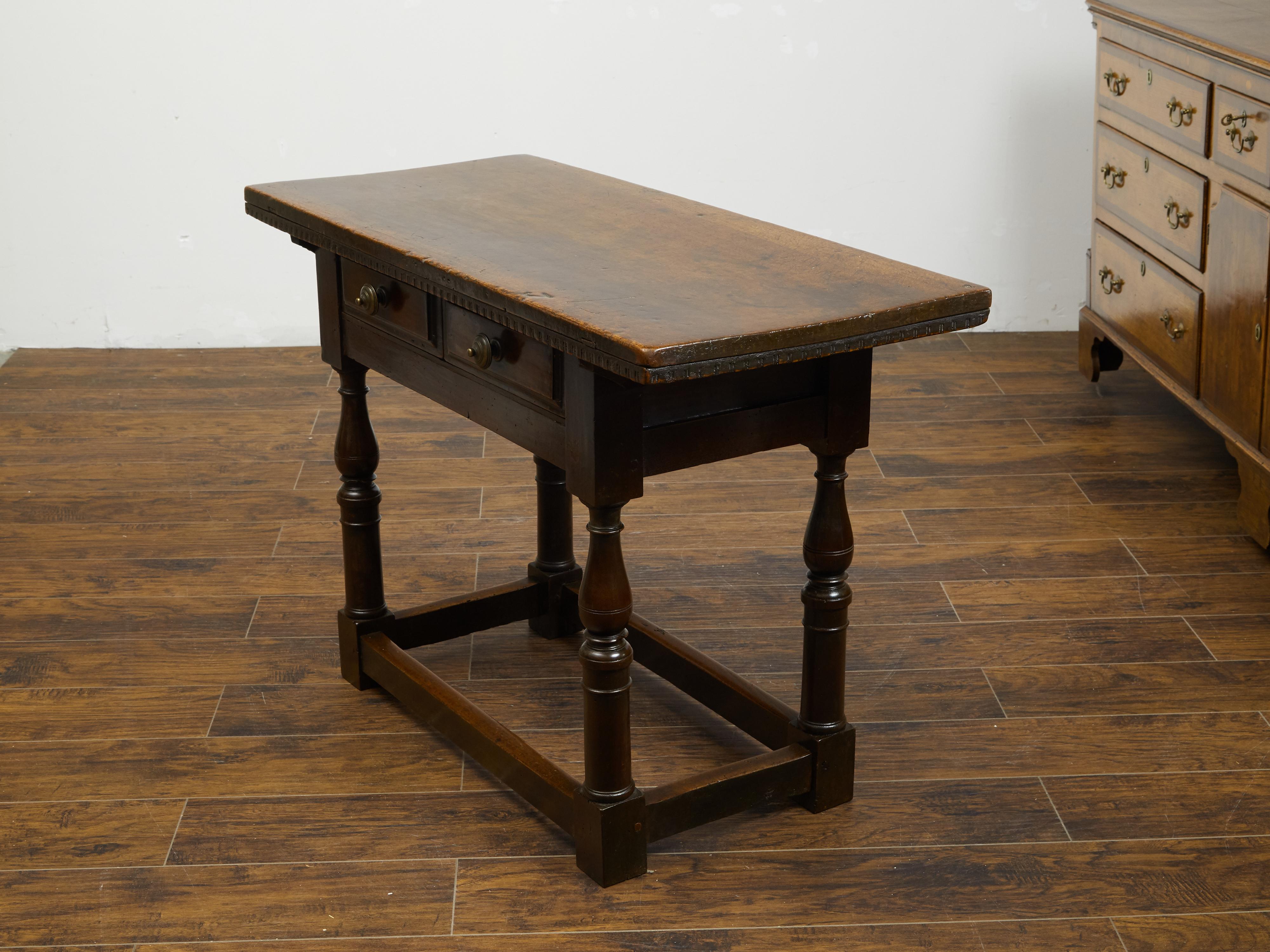 An Italian walnut console table from the early 19th century, with two drawers, turned legs and dentil molding. Created in Italy during the early years of the 19th century, this console table features a rectangular top adorned with a dentil molding,