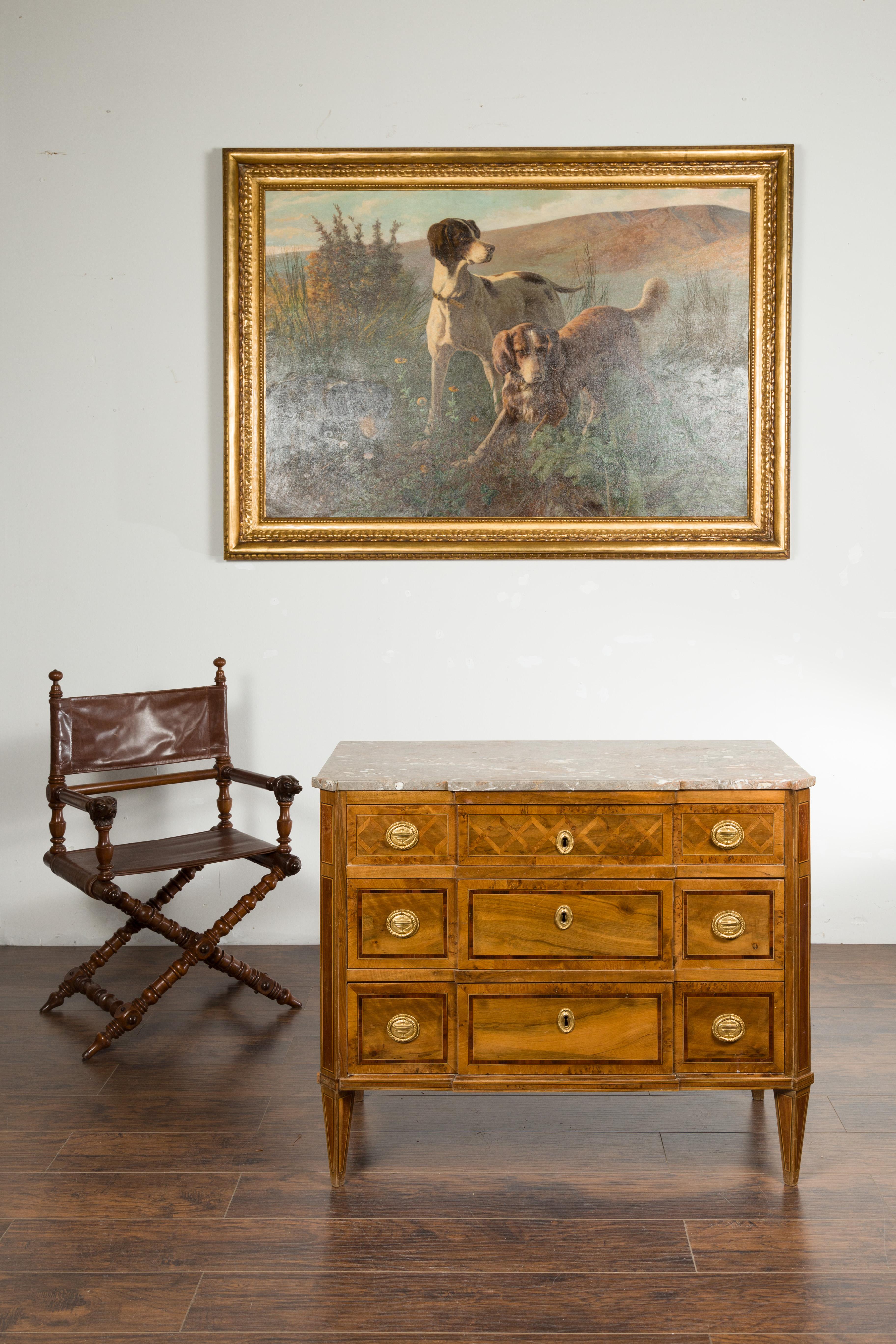 An Italian neoclassical period walnut commode from the early 19th century, with marble top and marquetry decor. Created in Italy during the first quarter of the 19th century, this neoclassical commode features a rectangular variegated marble top