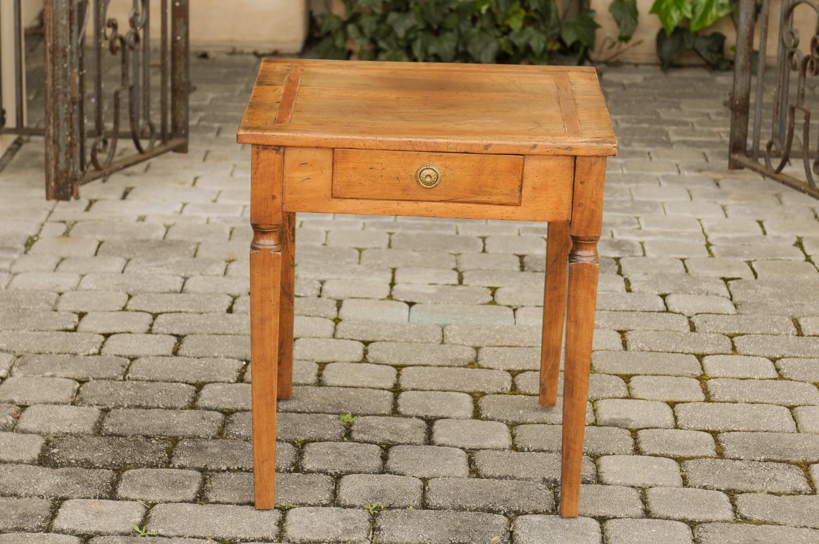 An Italian walnut neoclassical period side table from circa 1820, with single drawer and tapered legs. Born in Italy during the second decade of the 19th century, this exquisite walnut neoclassical period side table captures the essence of refined