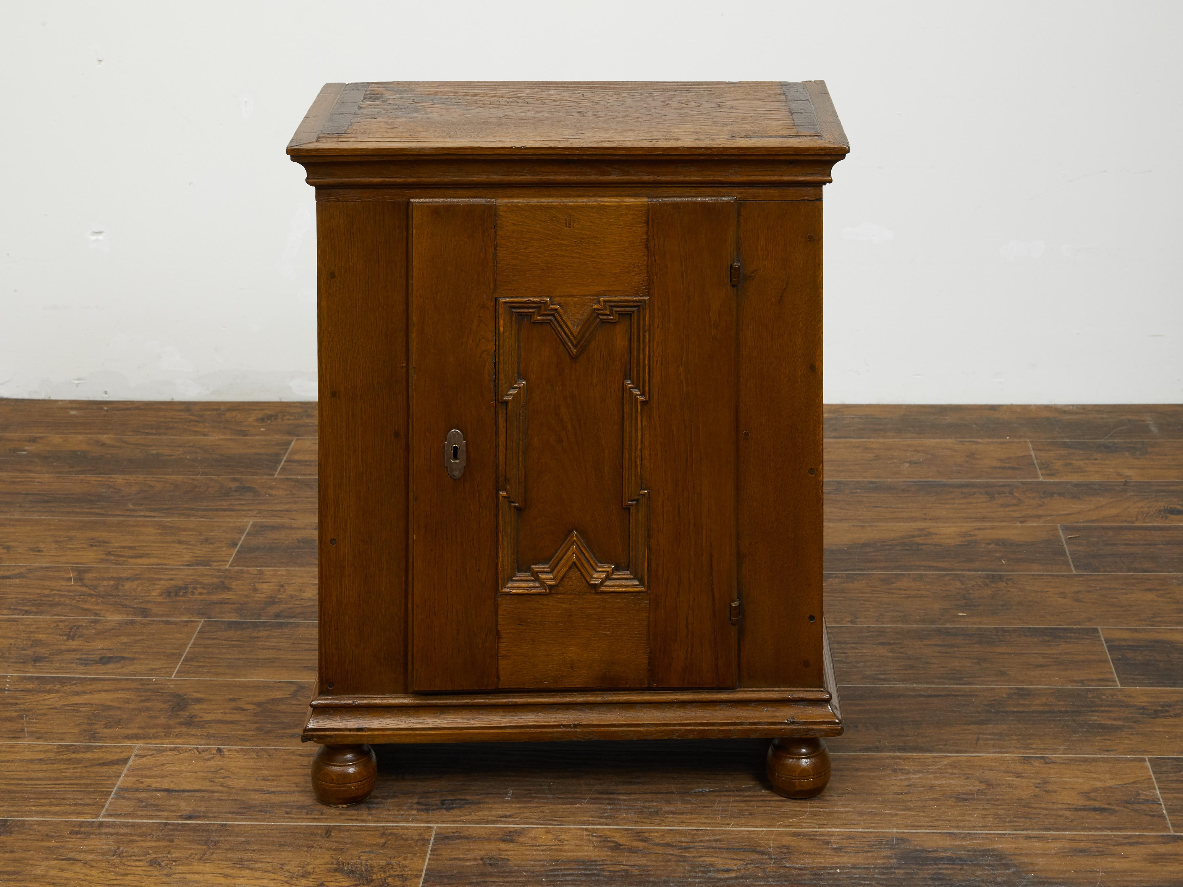 An Italian oak small cabinet from the early 19th century, with single door and geometric carved motif. Created in Italy during the first quarter of the 19th century, this small oak cabinet features a rectangular top sitting above a single door