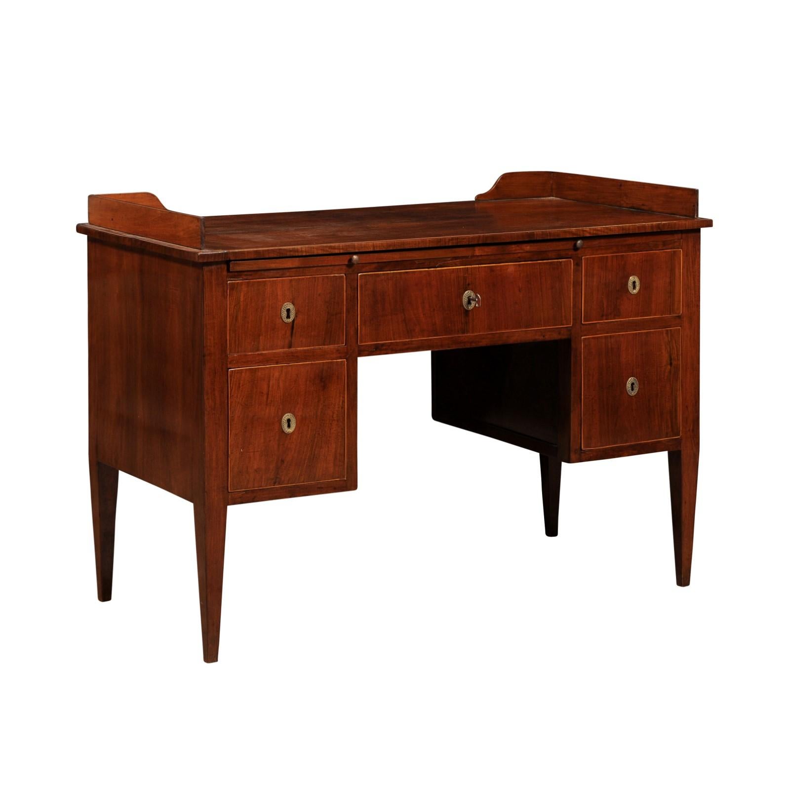 An Italian walnut and mahogany desk from circa 1820 with dark brown leather pull-out drawer, five drawers and thin banding around the drawers. This Italian walnut and mahogany desk from circa 1820 is a fine example of early 19th-century