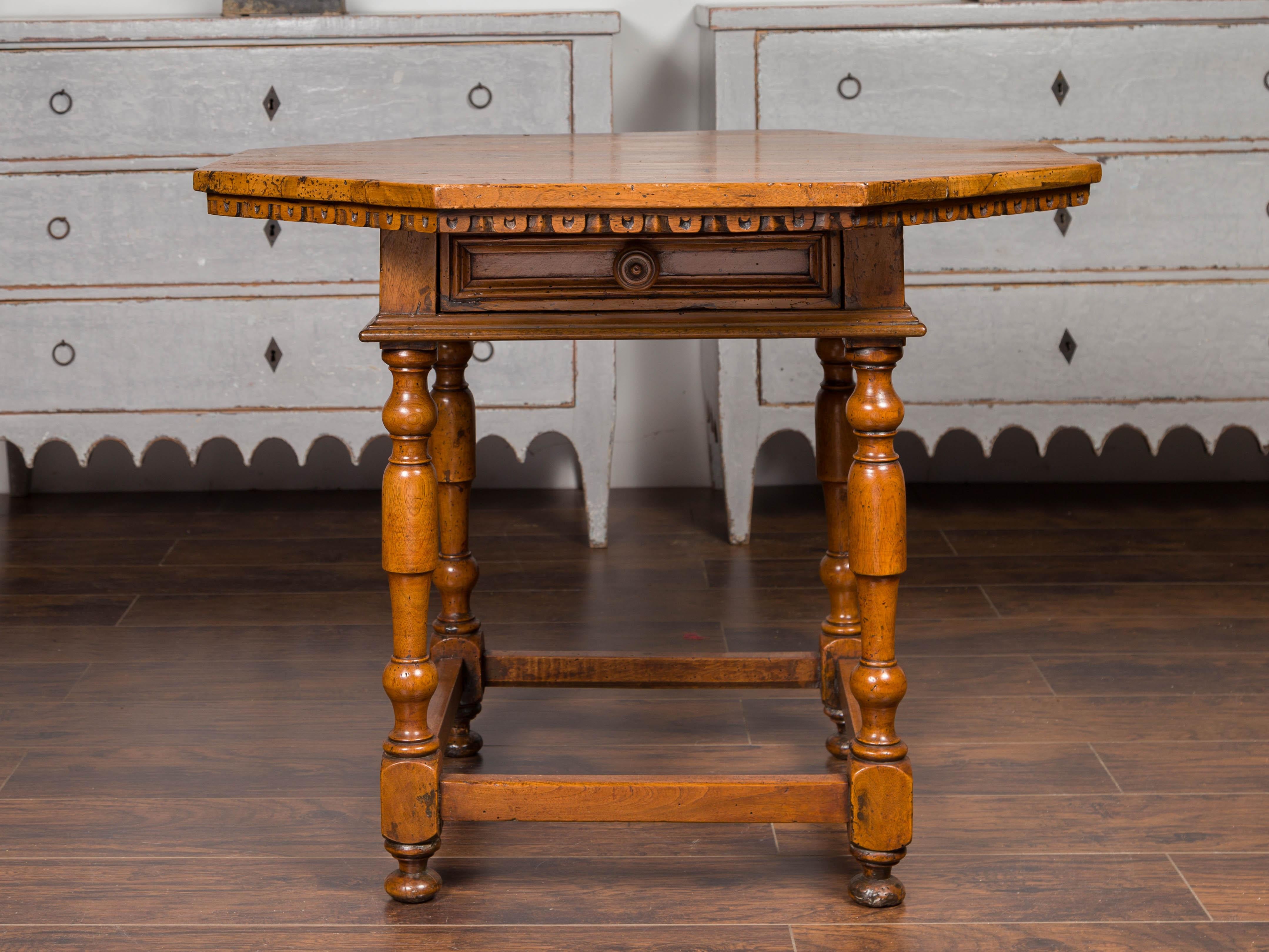 An Italian walnut center table from the early 19th century with octagonal top, carved molding and single drawer. Born in Italy during the first quarter of the 19th century, this center table features an octagonal top sitting above a carved molding
