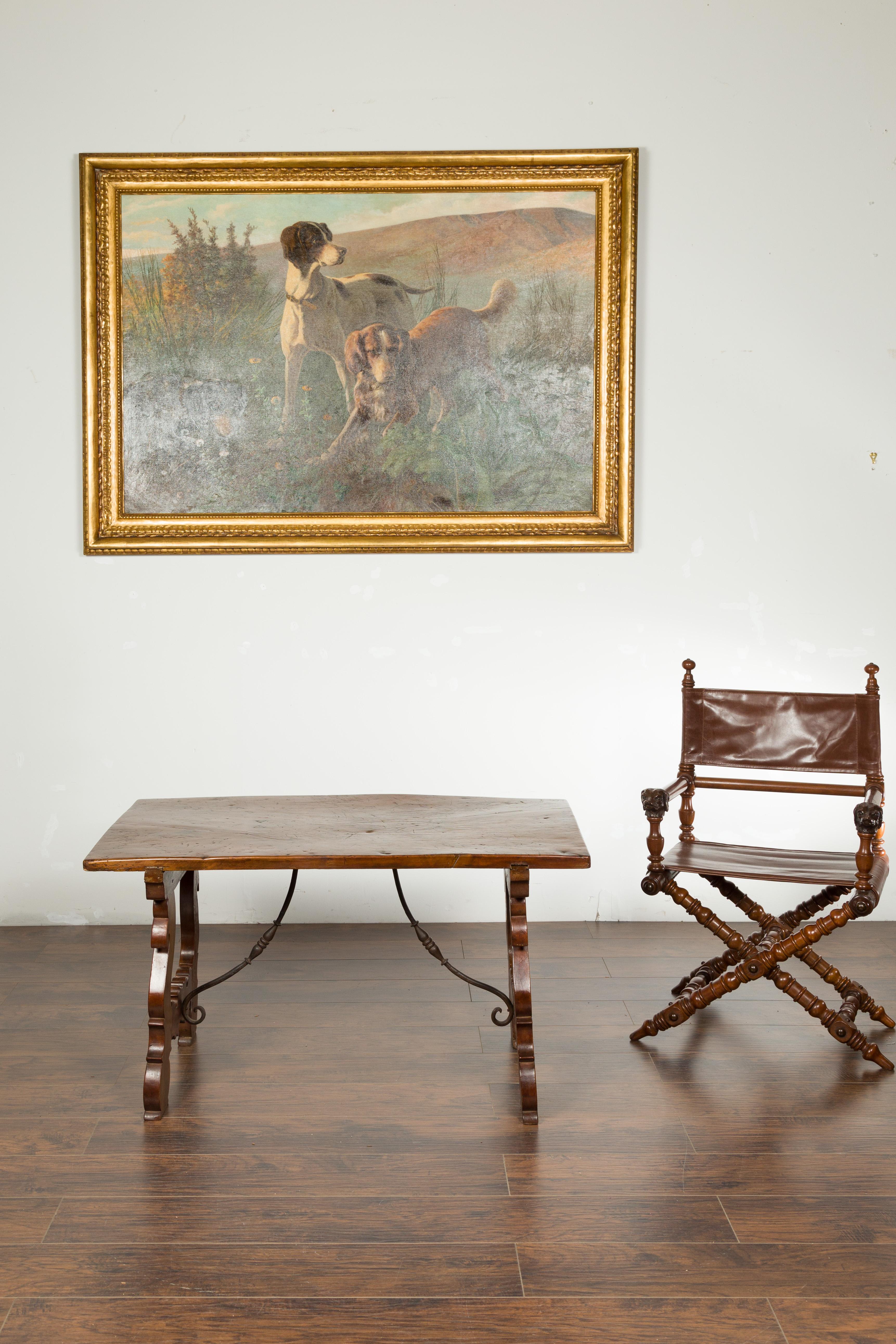 An Italian low fratino walnut table from the early 19th century, with wrought iron stretchers. Created in Italy during the first quarter of the 19th century, this walnut table features a single plank top with nice wear, sitting above a lyre shaped