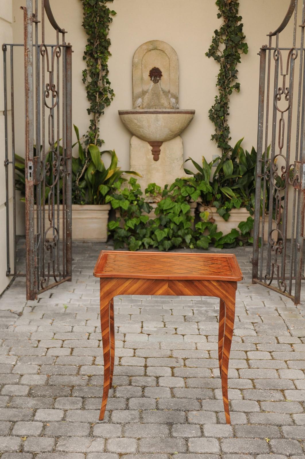 An Italian walnut side table from the early 19th century, with marquetry top, lateral drawer and inlaid legs. Born in Italy during the first quarter of the 19th century, this exquisite side table features a rectangular top with three-quarter gallery