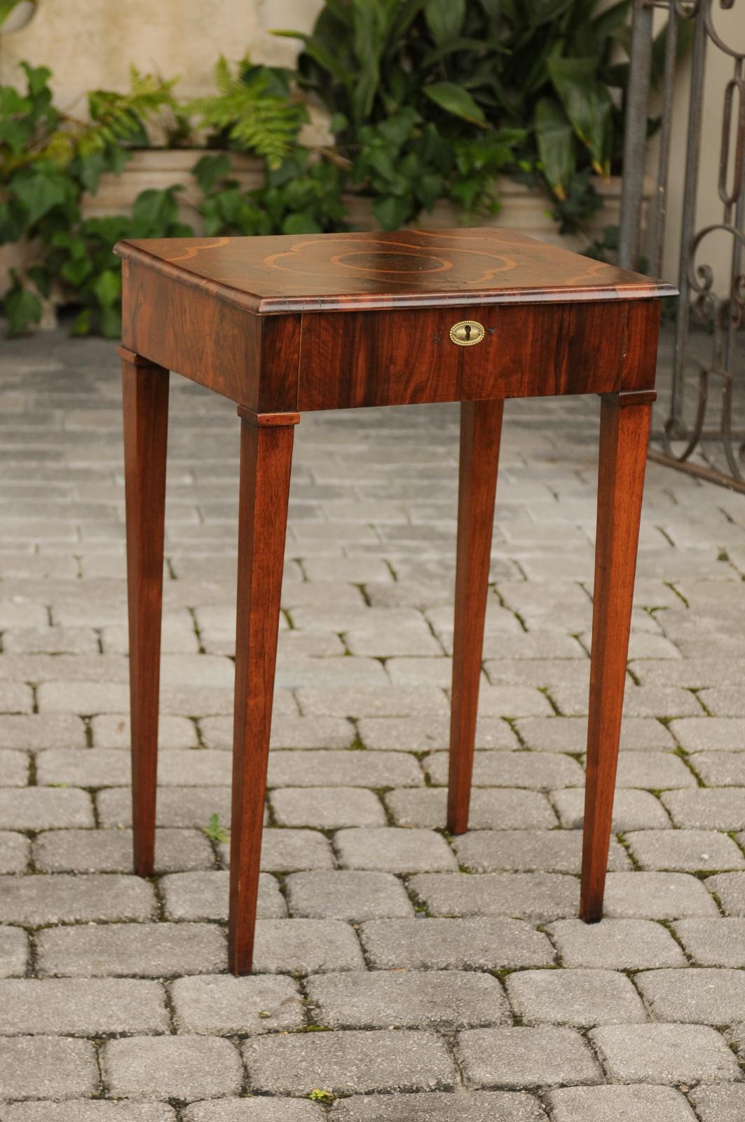 An Italian walnut side table from the early 19th century with oyster veneered top, quadrilobe inlay, single drawer and tapered legs. Born in the first quarter of the 19th century, this Italian walnut table features an exquisite oyster veneered top,